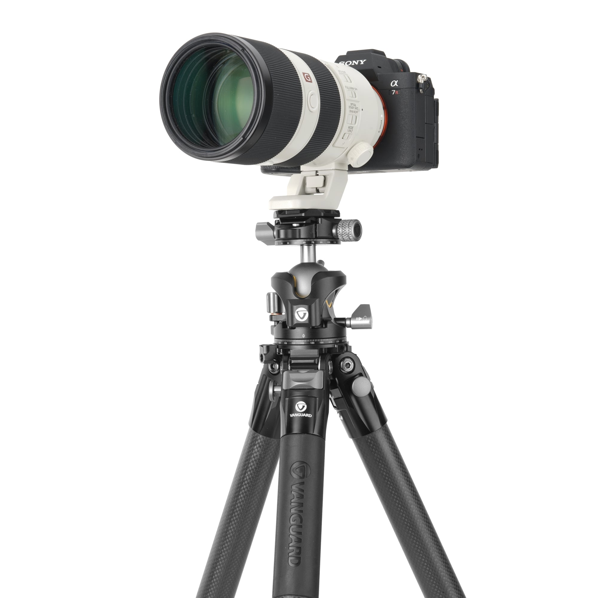 Una cámara Sony Alpha 7R con un objetivo blanco sobre un trípode Vanguard negro.