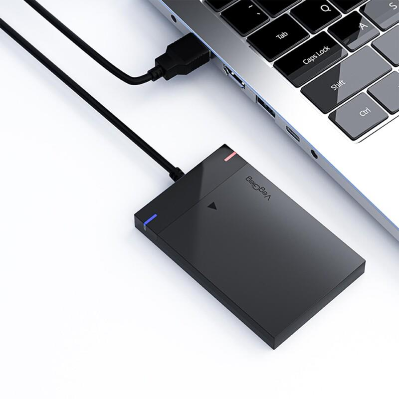 Siyah harici sabit disk, USB kablosuyla bir dizüstü bilgisayara bağlı.