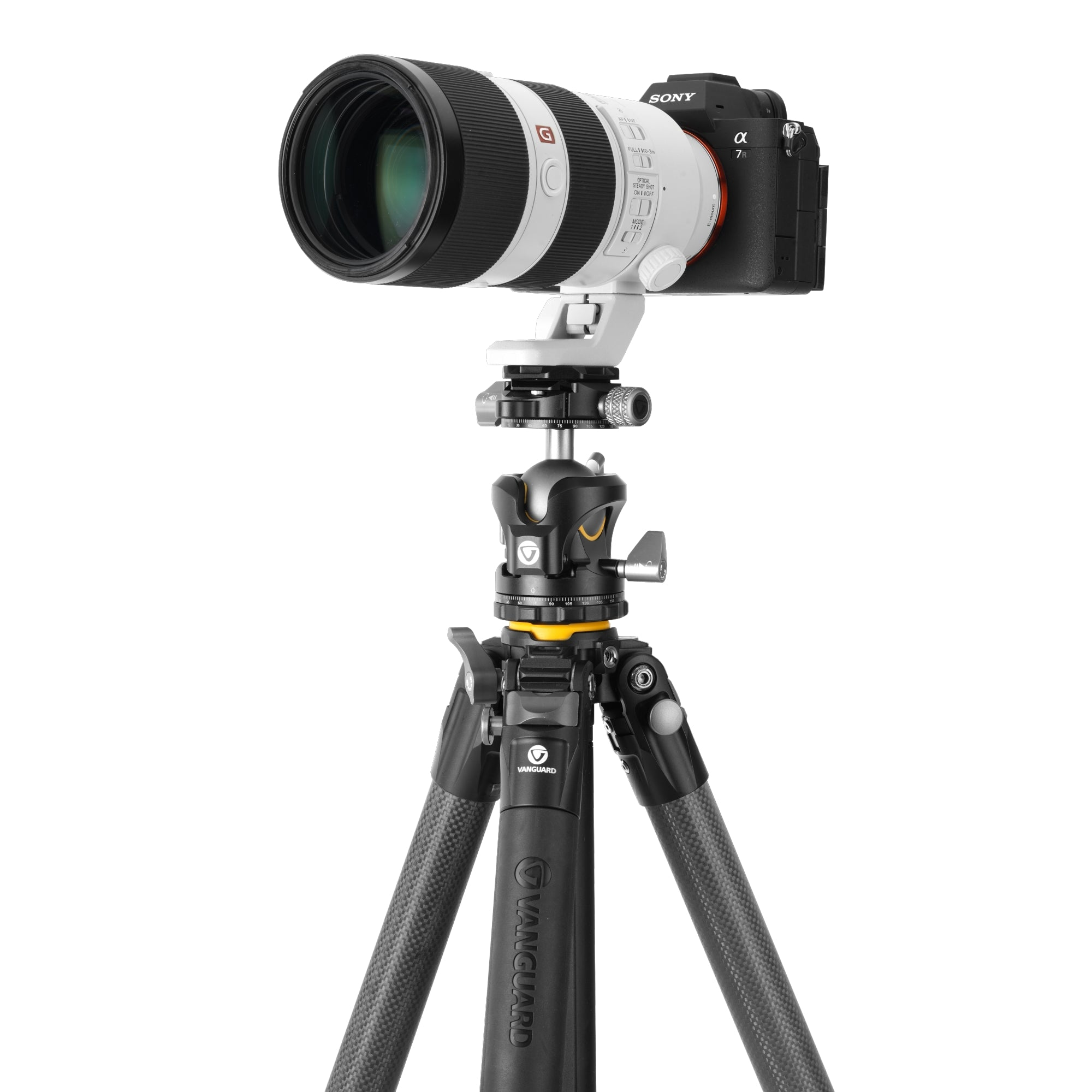 Una cámara Sony Alpha 7R con un teleobjetivo blanco sobre un trípode Vanguard negro.