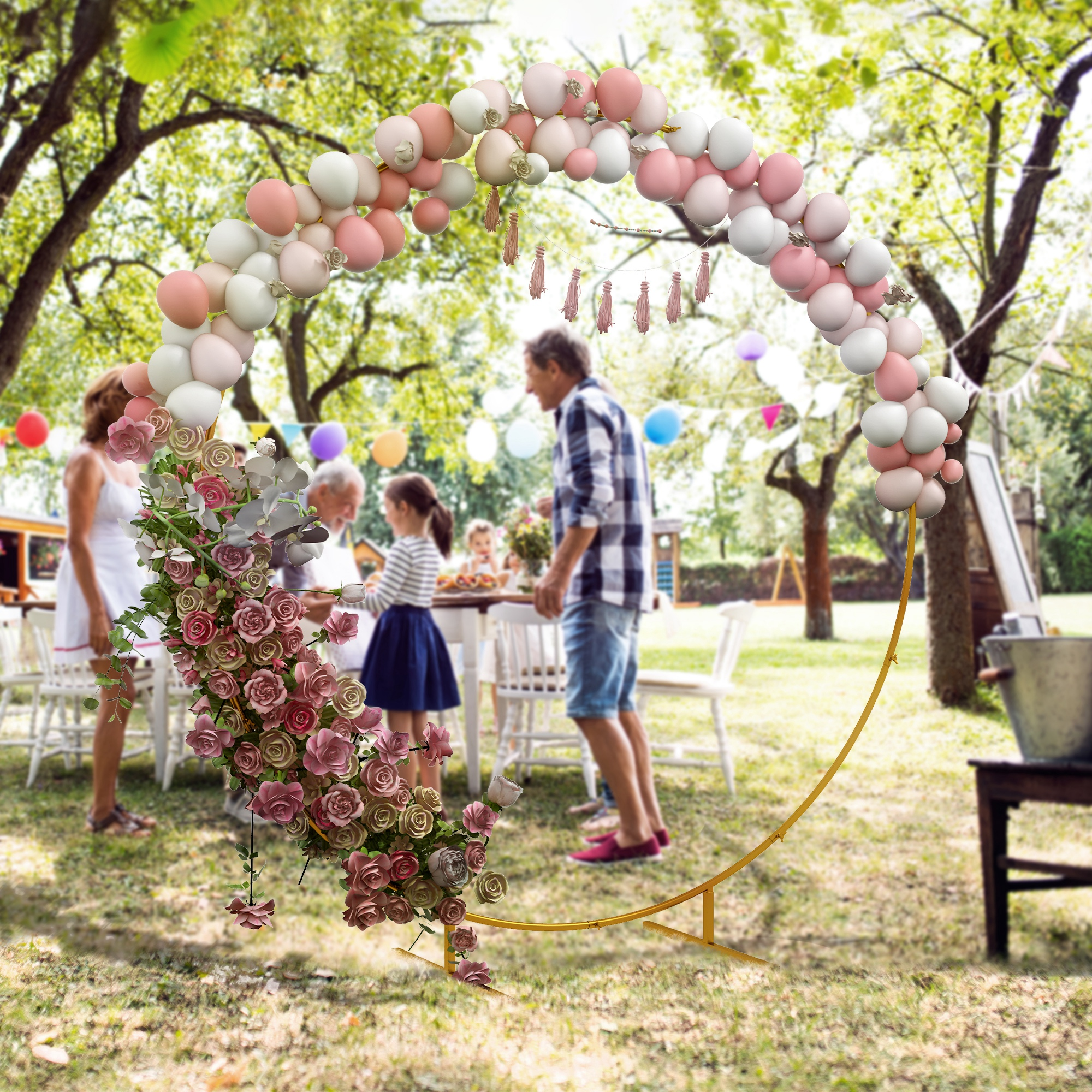 Festa in giardino con arco di palloncini, fiori e invitati.