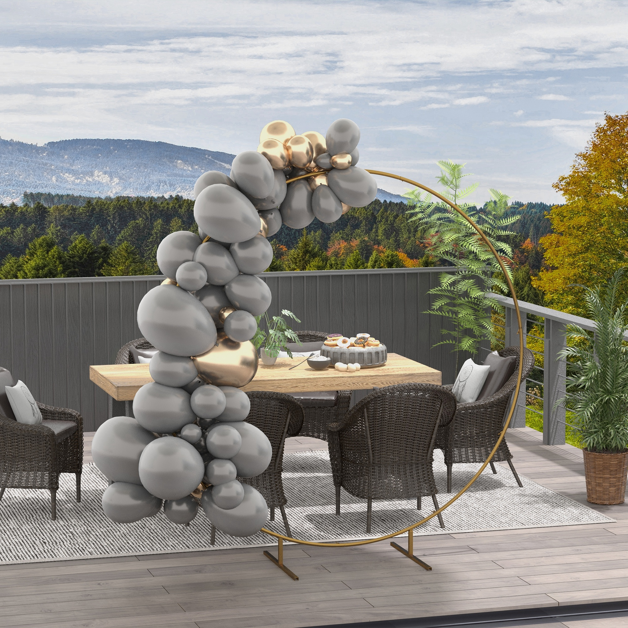 Palloncini grigi e dorati su un balcone con sfondo montano e tavolo da pranzo.