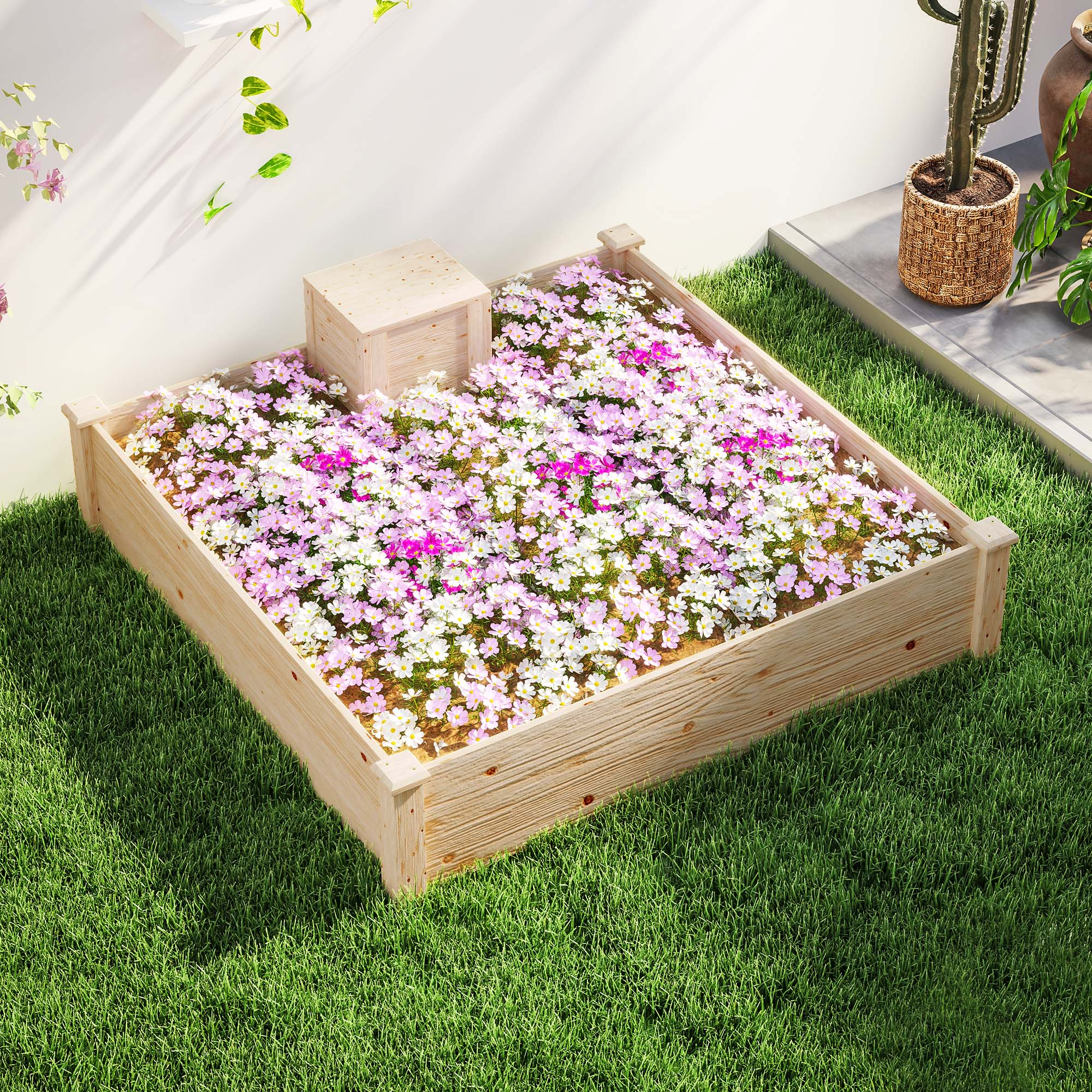 Un'aiuola rialzata in legno piena di fiori bianchi e rosa, su erba verde.