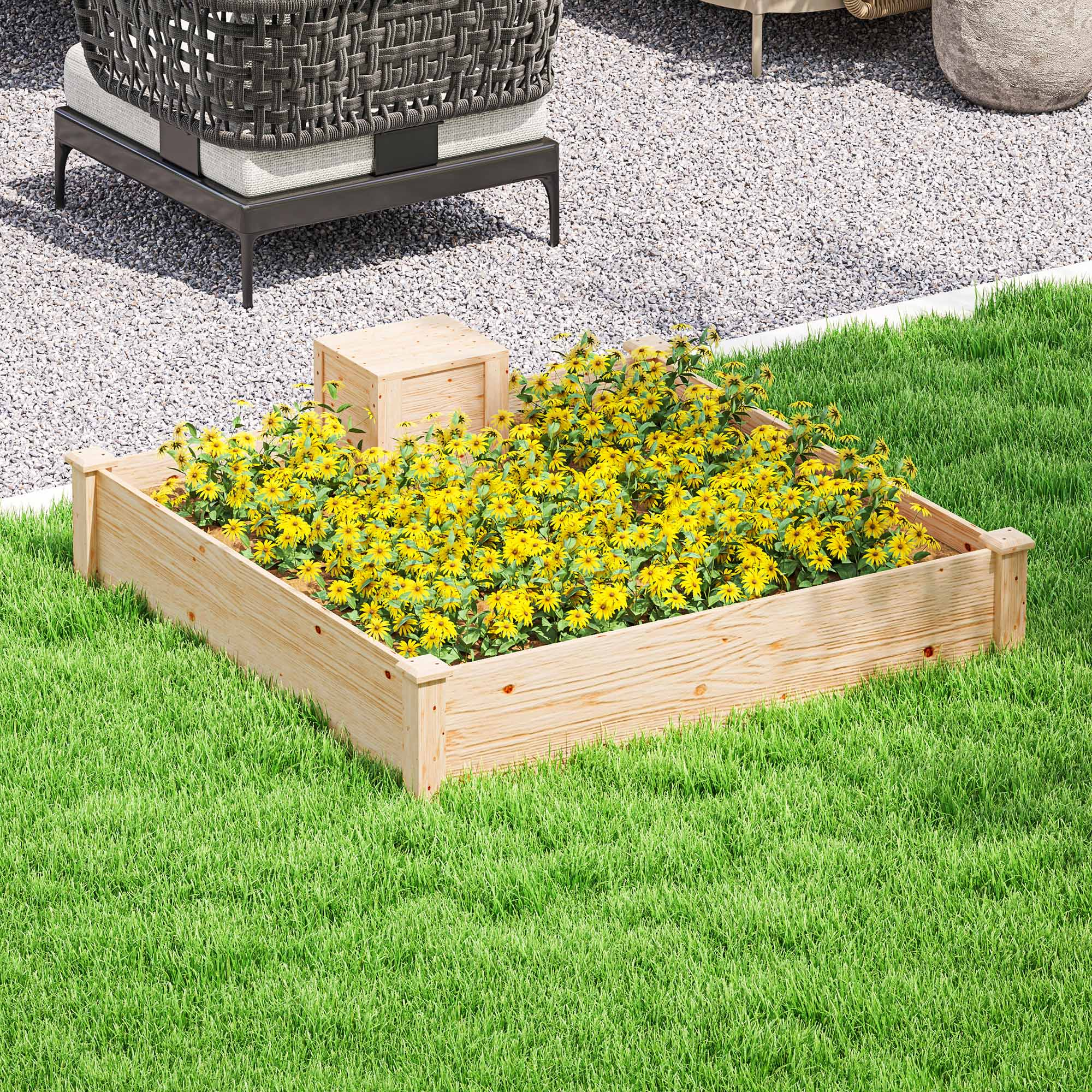 Un letto rialzato in legno pieno di fiori gialli su un prato vicino a ghiaia e mobili.