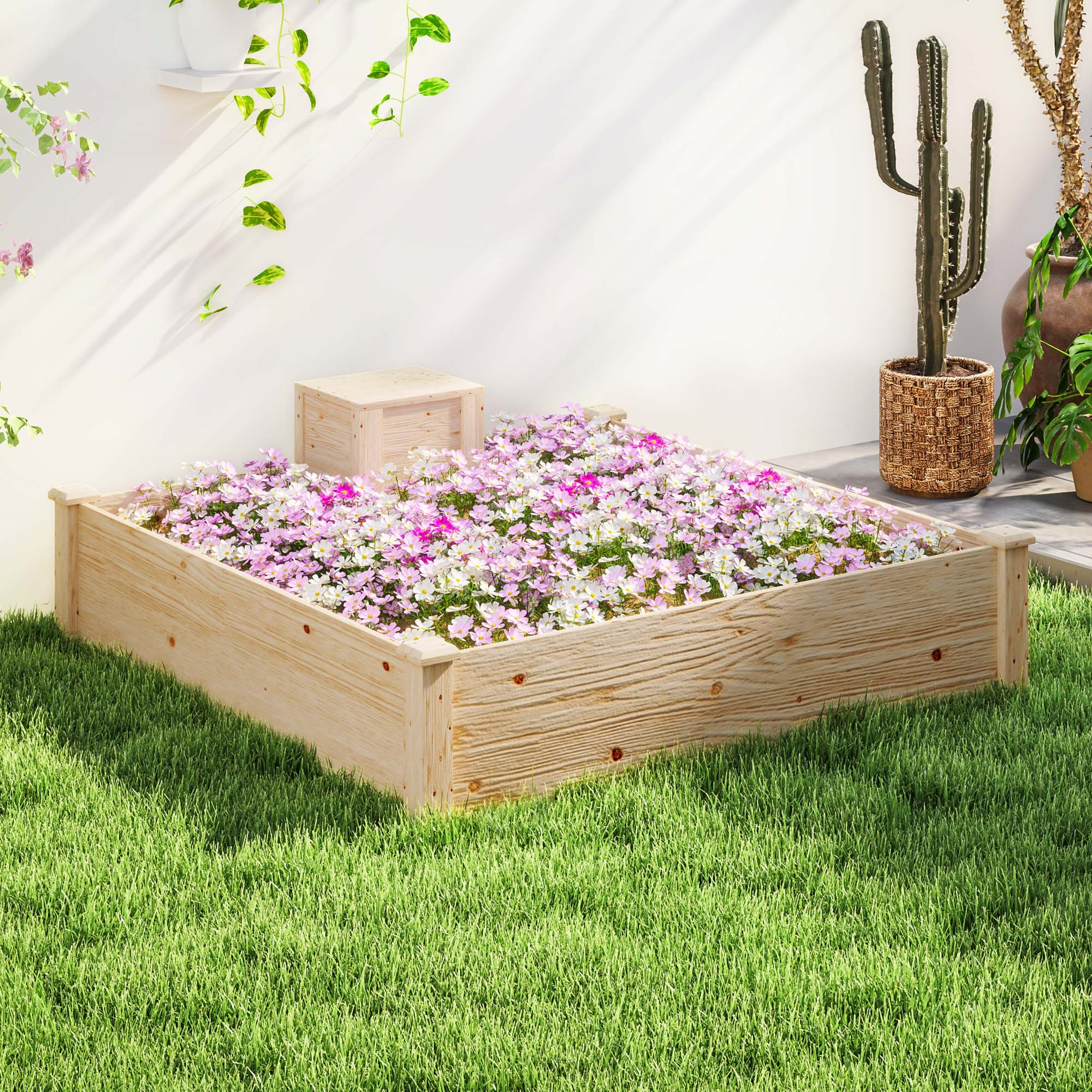 Un letto rialzato in legno pieno di fiori rosa e bianchi su erba verde.