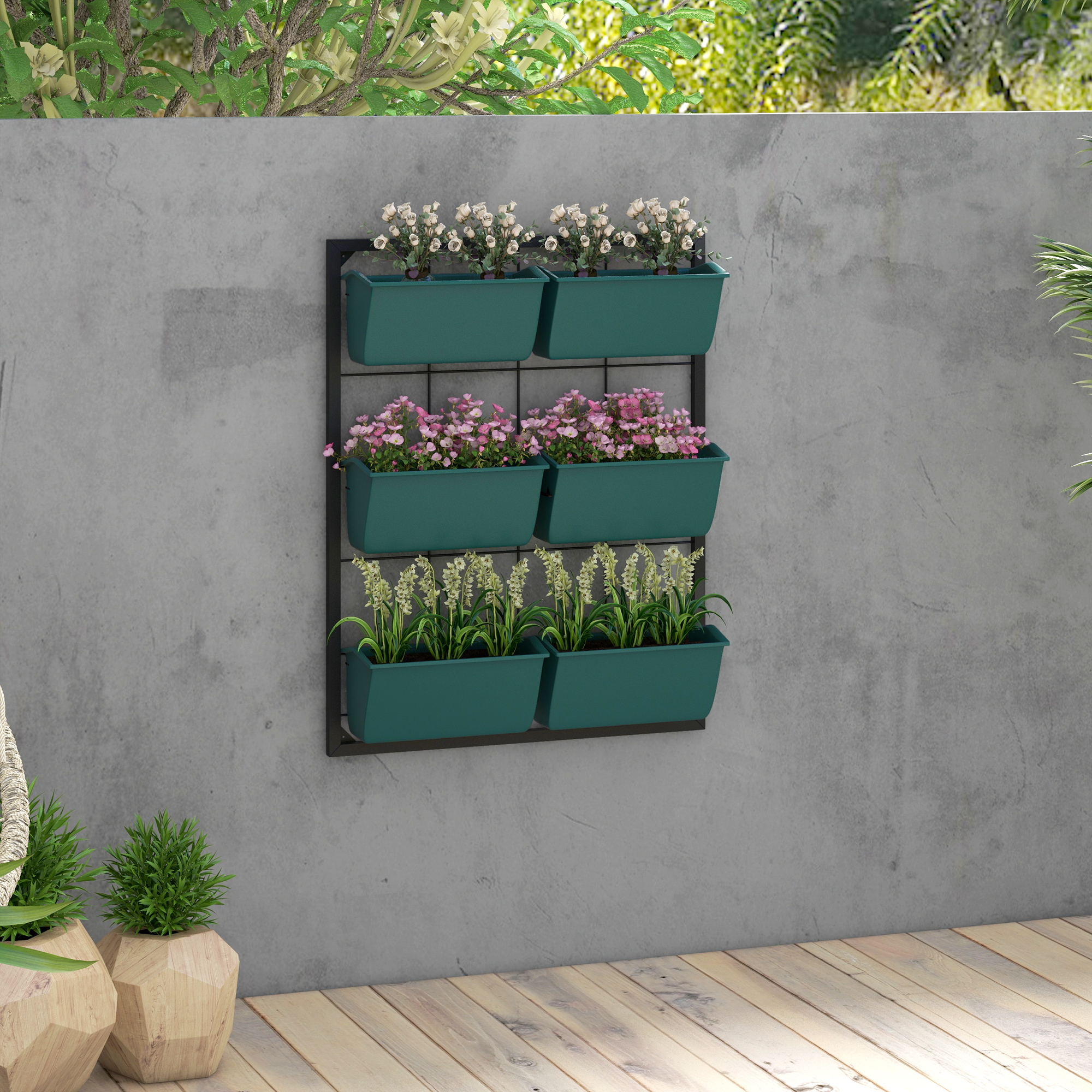 Giardino verticale con fioriere verdi contenenti fiori bianchi, rosa e gialli su muro di cemento.