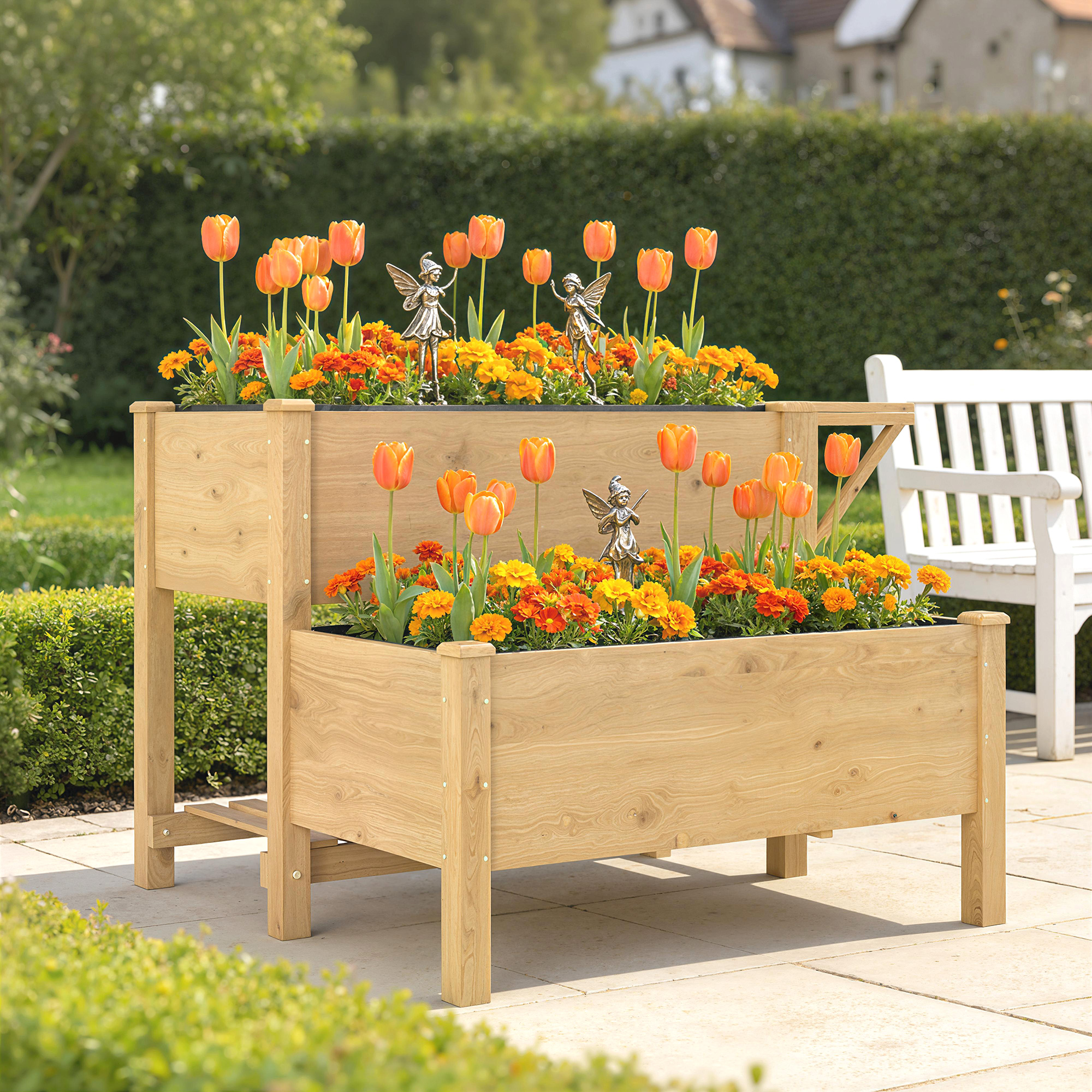 Due fioriere rialzate in legno con tulipani e fiori arancioni, due figure di fate.
