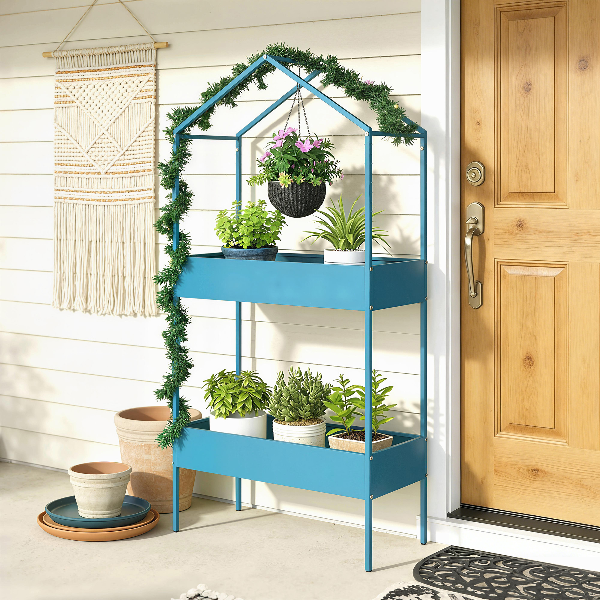Un porta piante blu con ghirlanda verde davanti a una porta, con arazzo in macramè.