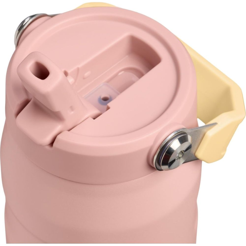 Sarı kulplu, pipet açıkluğu olan pembe mataradan bir yakın çekim.