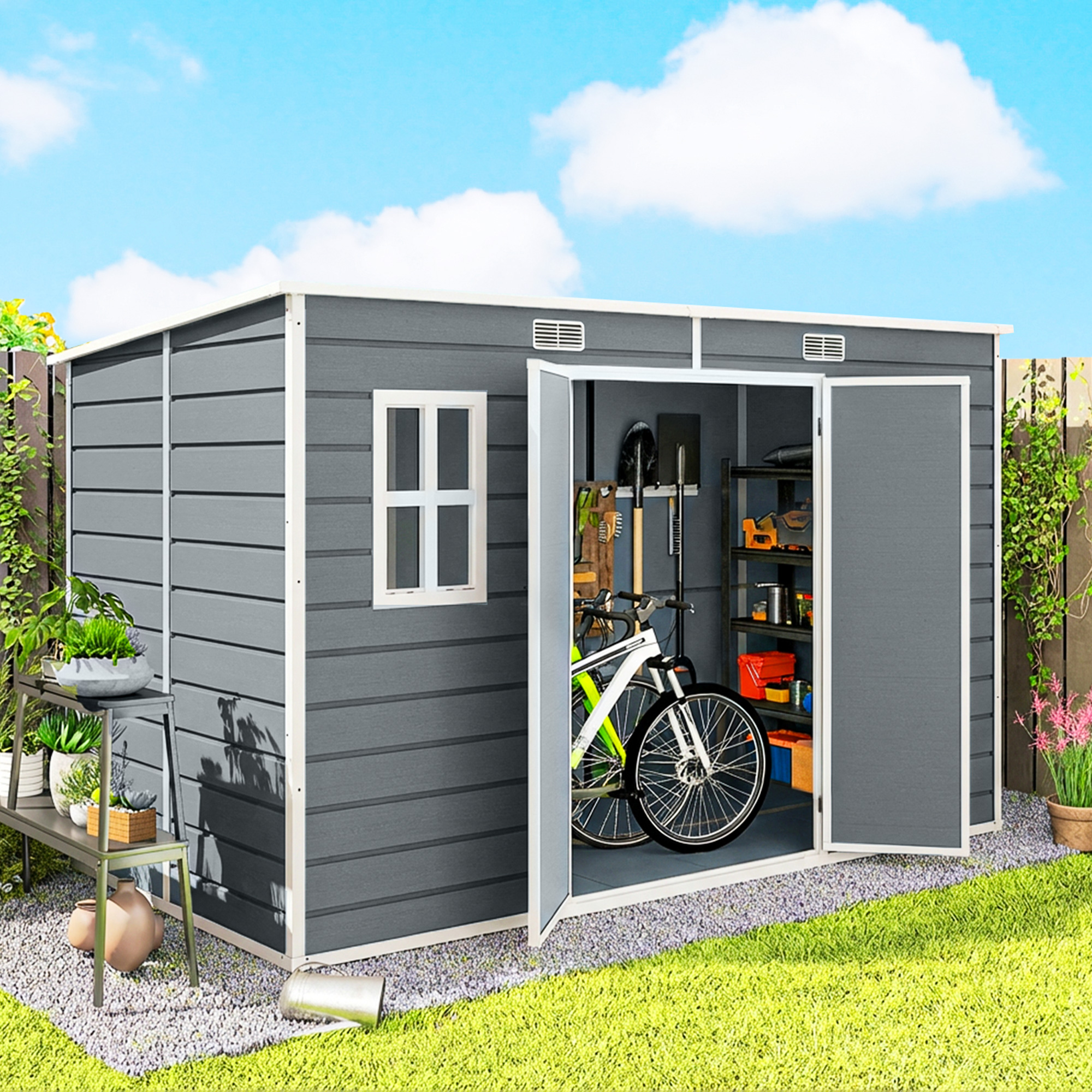 Capanno da giardino grigio con porta aperta, bicicletta e attrezzi all'interno. Giorno soleggiato.