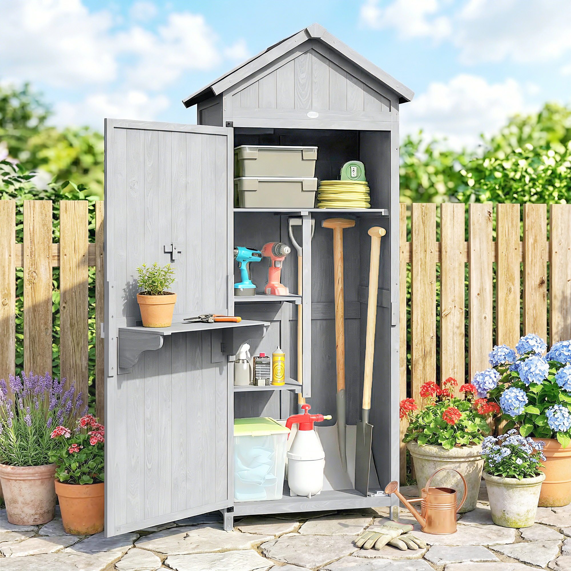 Una casetta da giardino grigia con attrezzi e piante davanti.