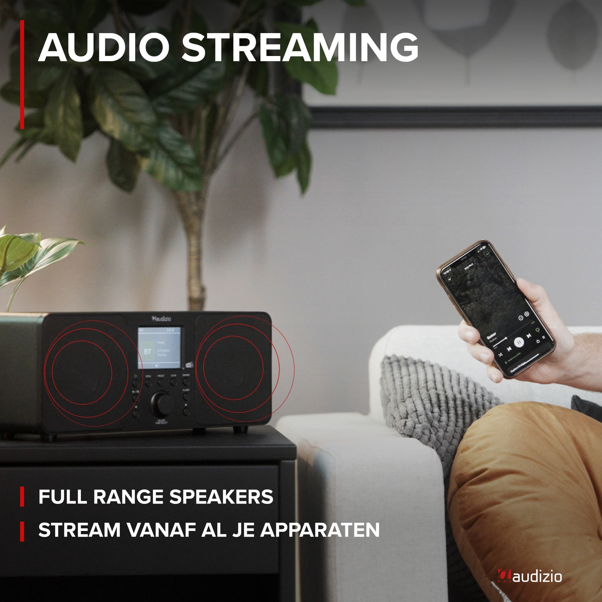 Ein Mann hält ein Smartphone vor einem Audizio-Lautsprecher mit dem Text AUDIO STREAMING.