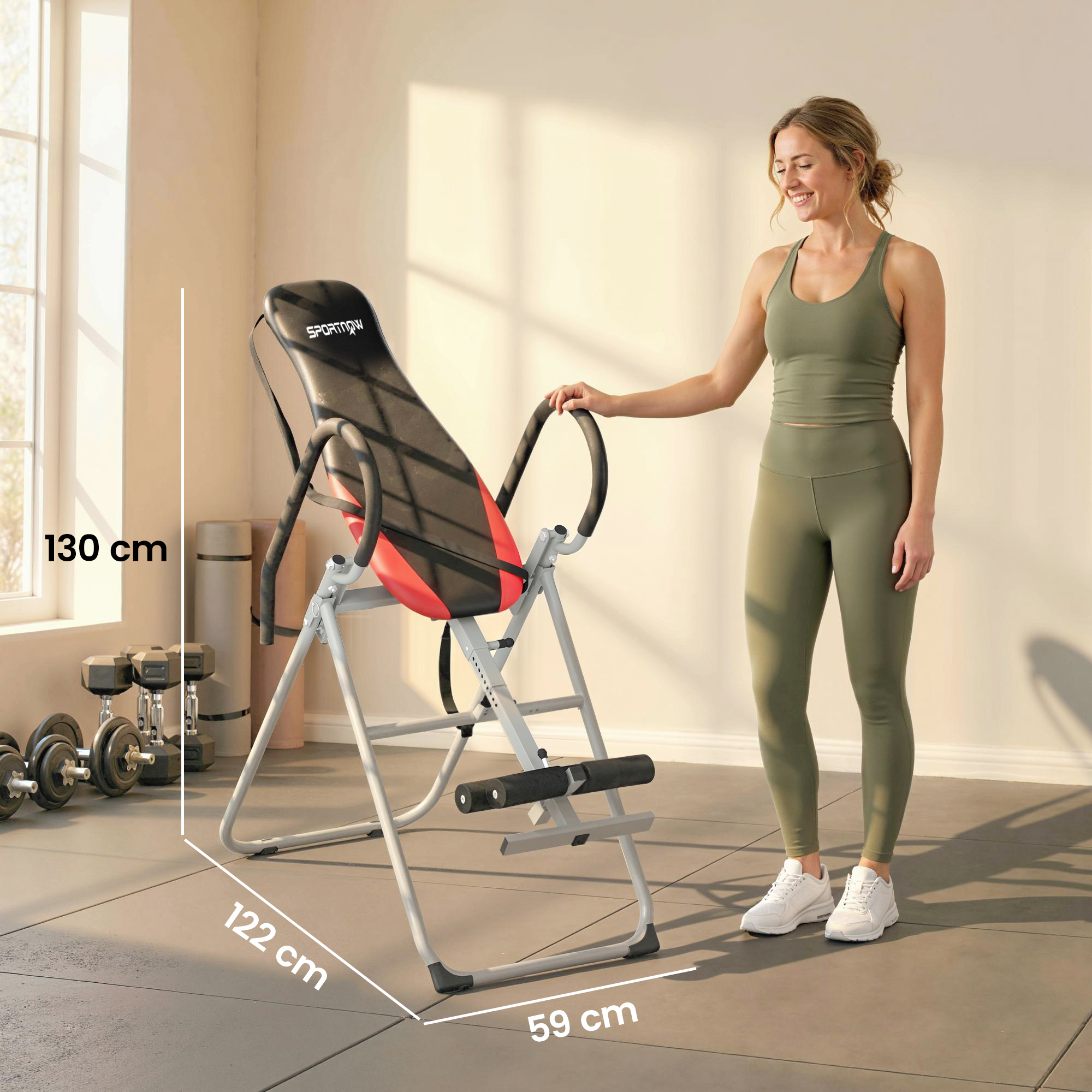 Una donna in abiti da allenamento è accanto a un tavolo di inversione in palestra.