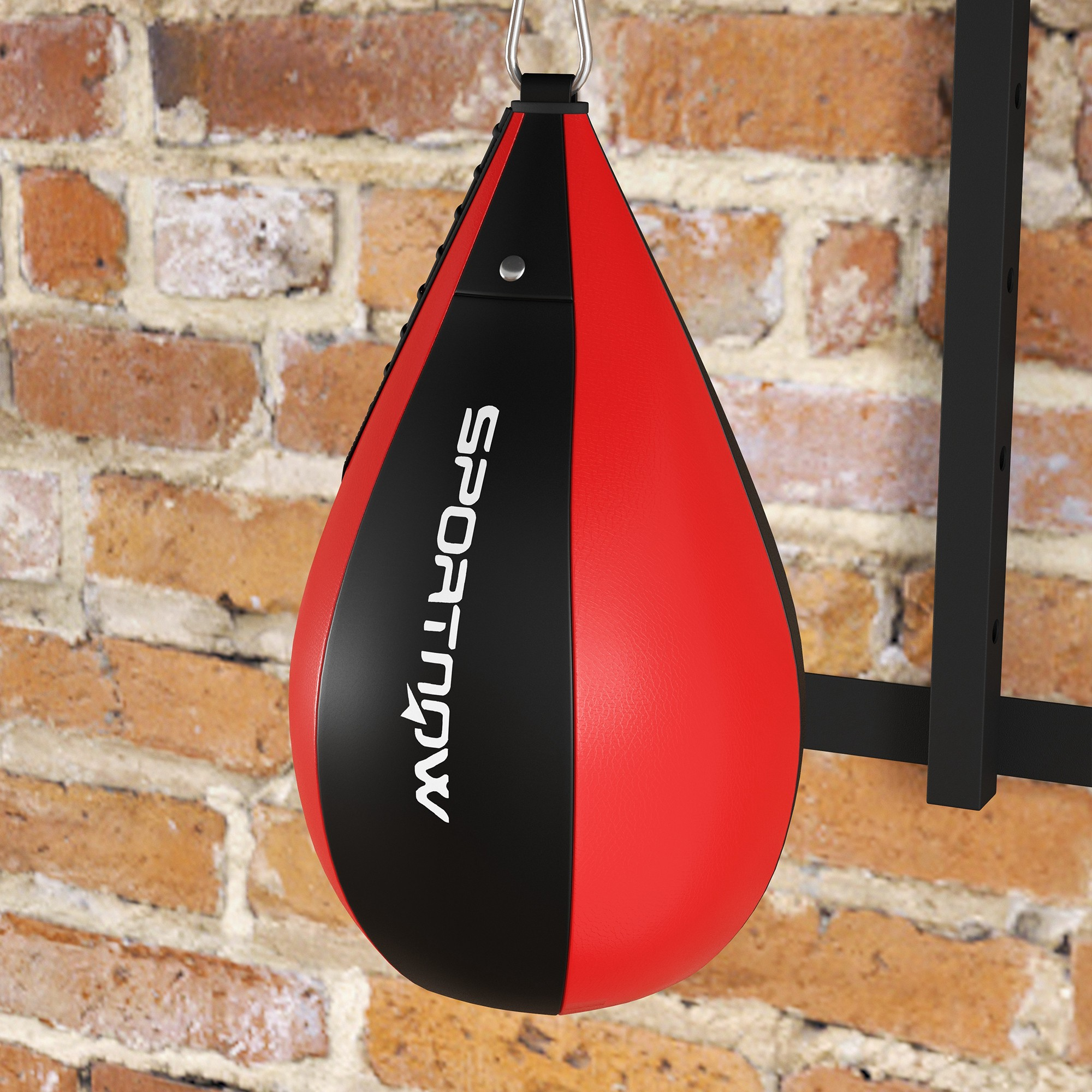 Un sacco da boxe rosso e nero è appeso a un muro di mattoni.