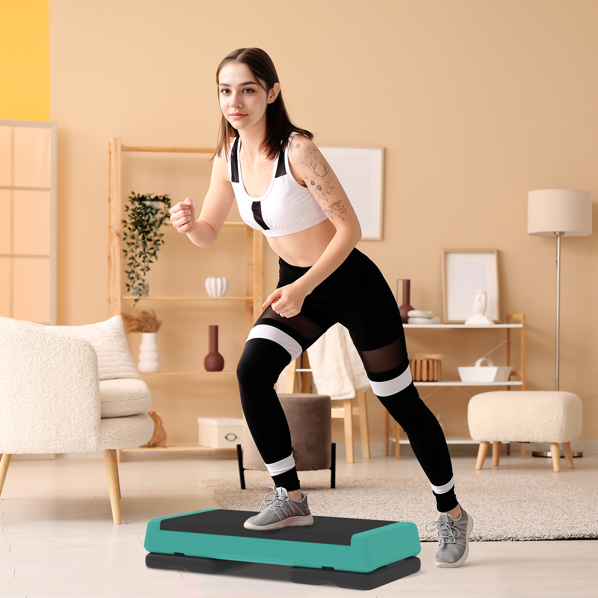 Una donna in abbigliamento sportivo si allena su una piattaforma step in un soggiorno.