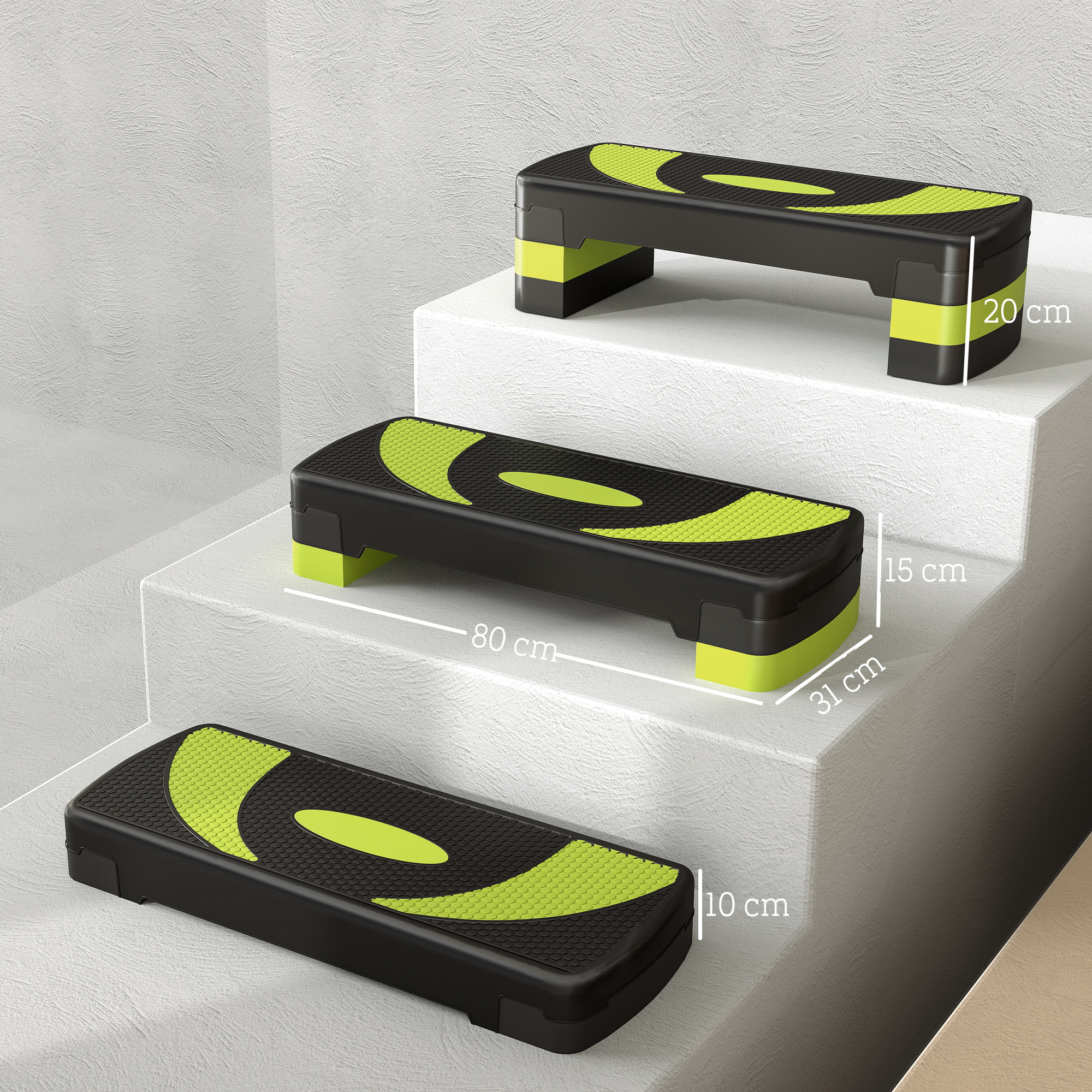 Tre step aerobici neri con accenti verde neon su gradini bianchi.