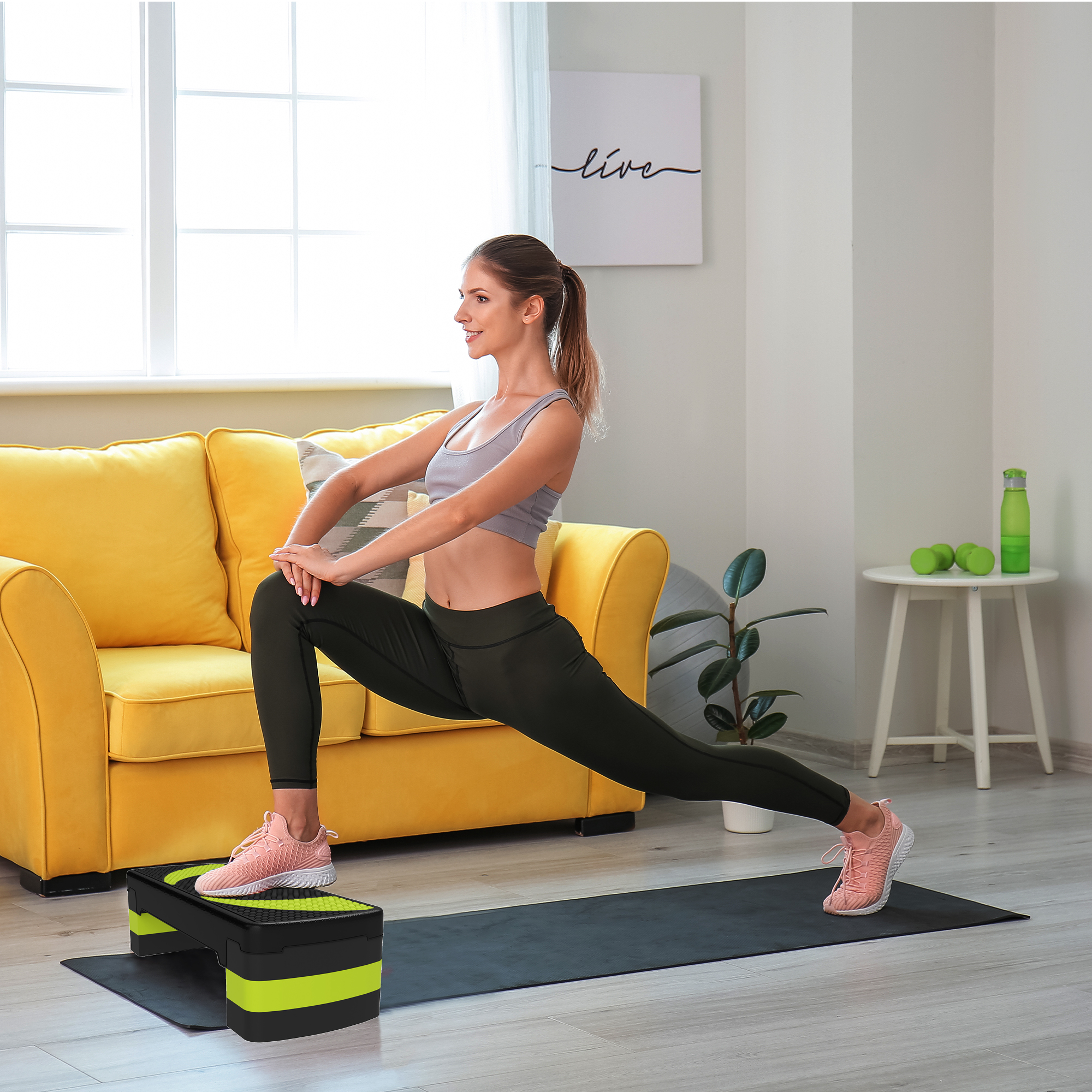 Una donna si allunga a casa su un tappetino con una step box.