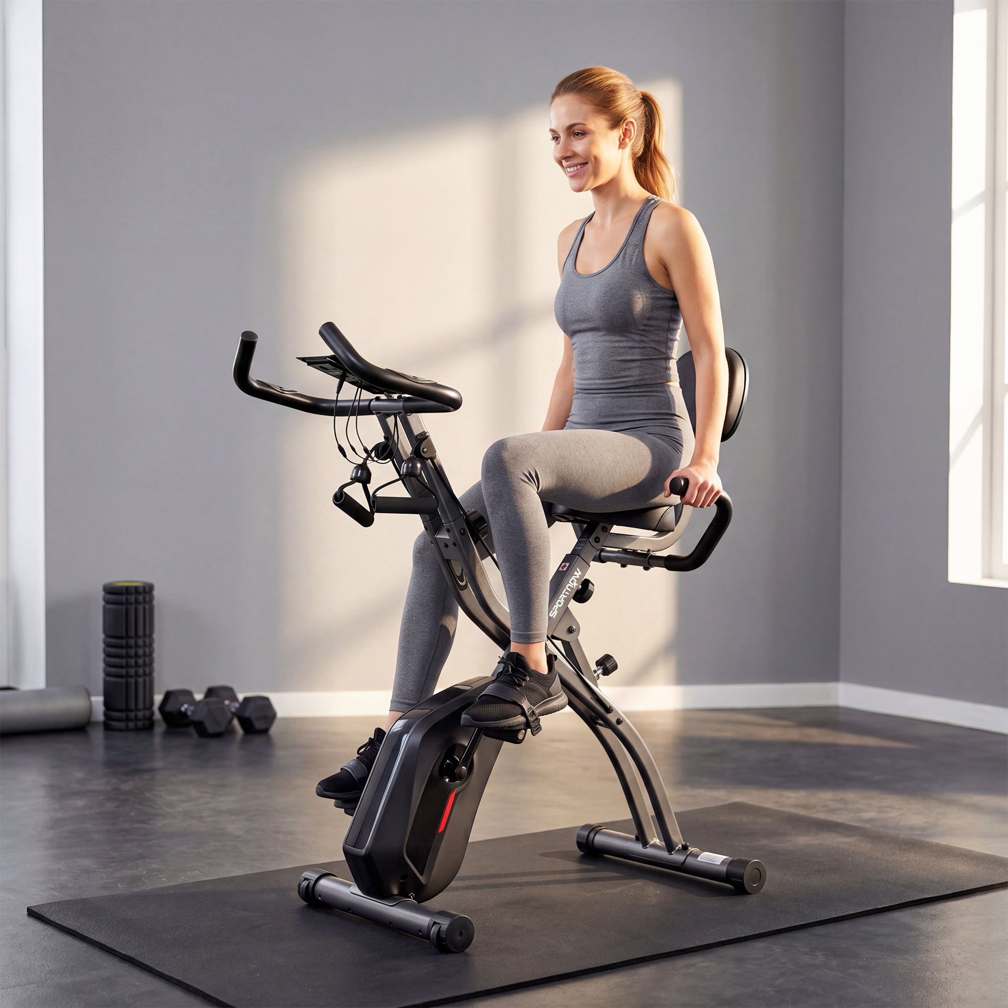 Una donna in abiti da allenamento su una cyclette in una palestra.