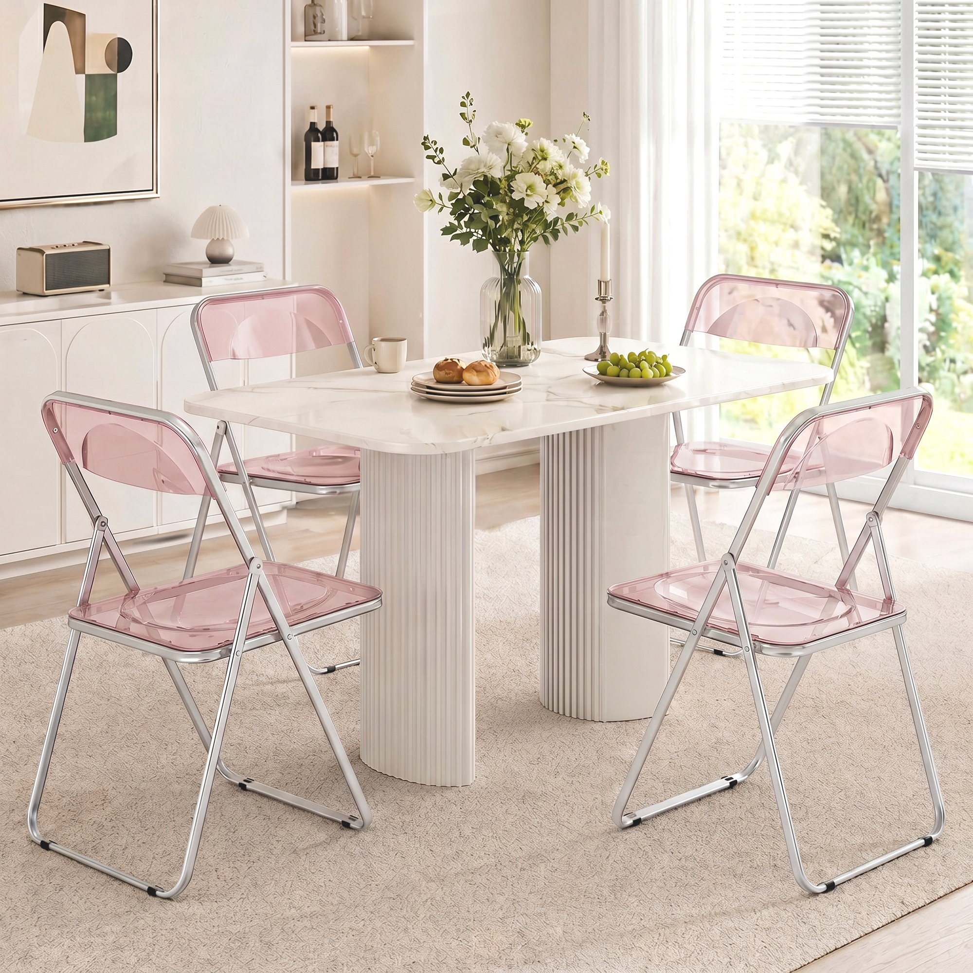 Moderna zona pranzo con tavolo in marmo, quattro sedie rosa traslucide e fiori.