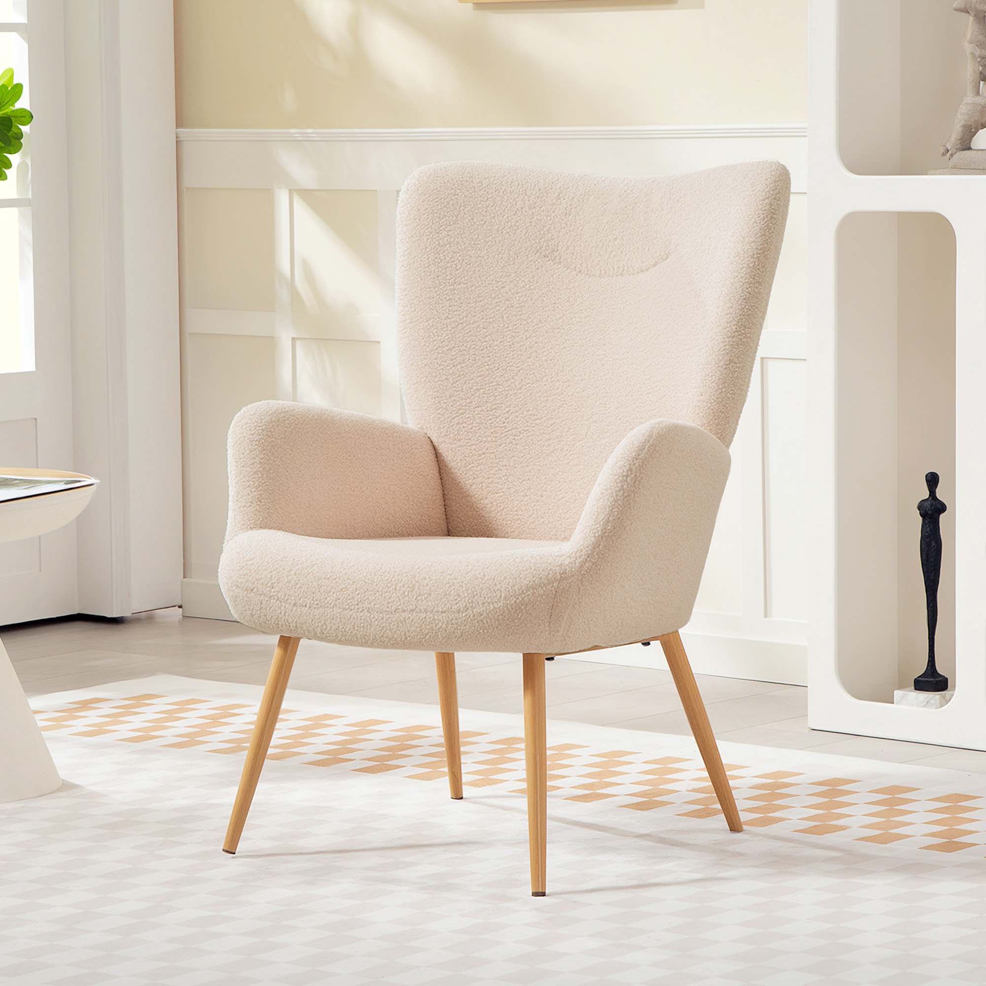 Una poltrona bouclé color crema con gambe in legno su un tappeto.
