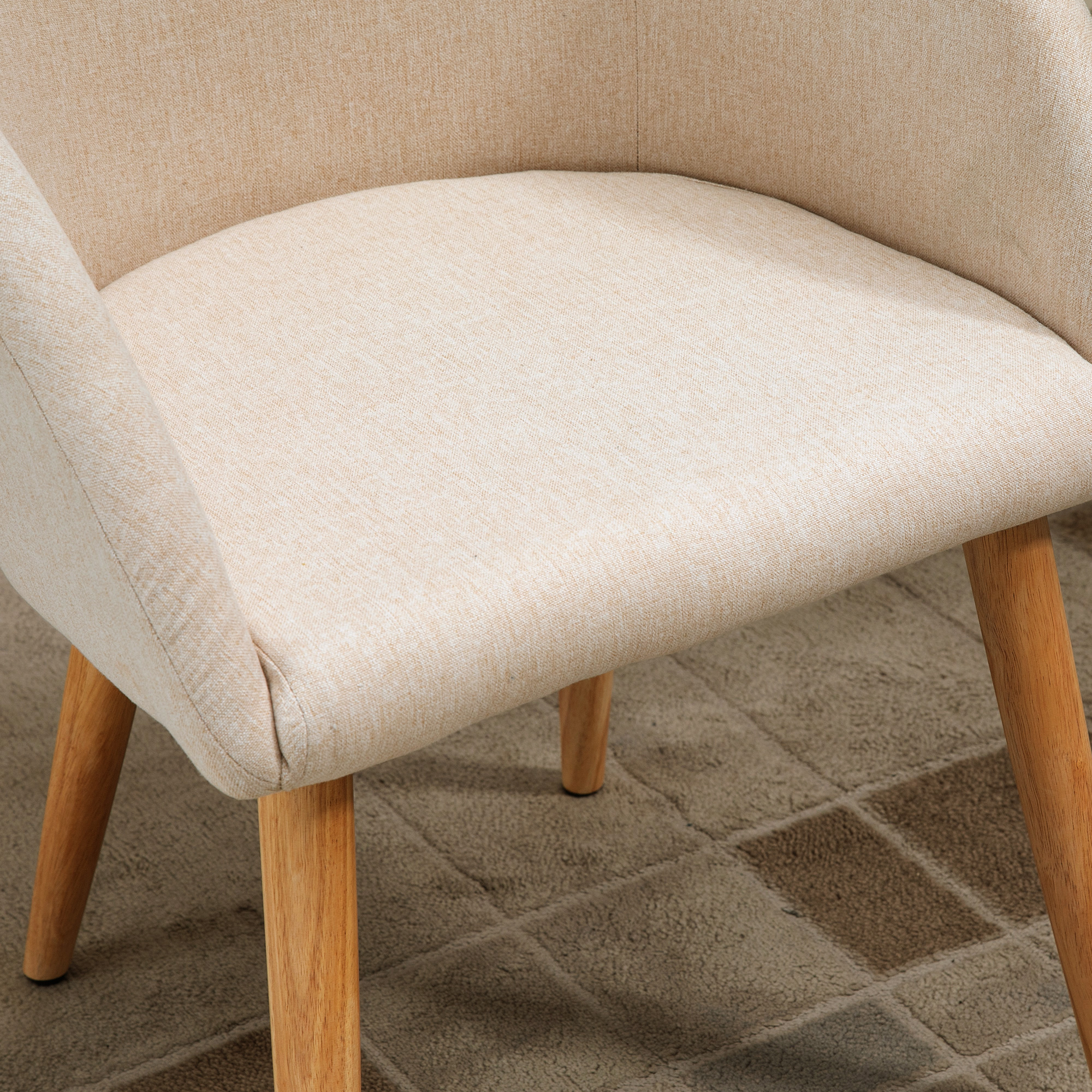 Una sedia in tessuto beige con gambe in legno su un tappeto.