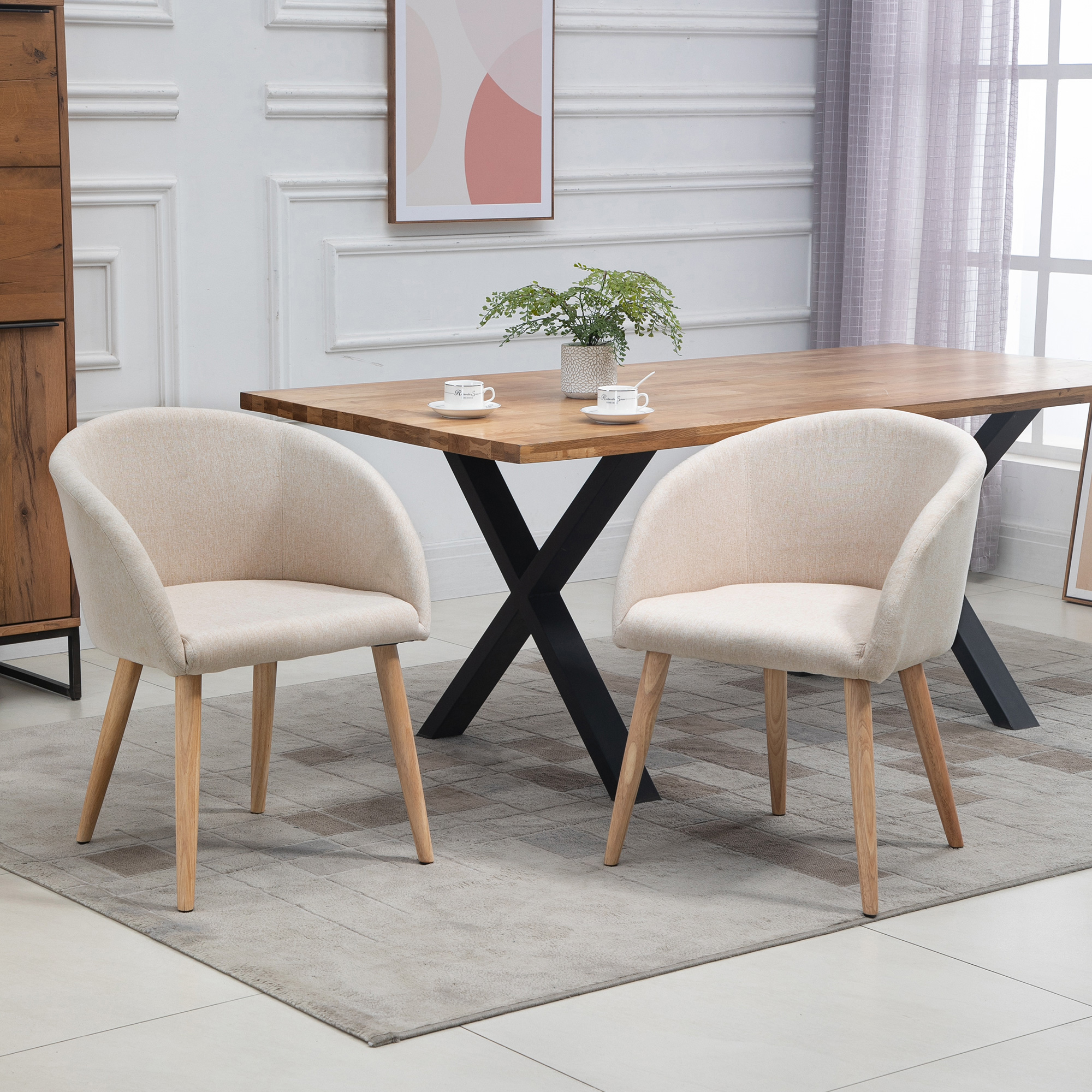 Due sedie beige davanti a un tavolo di legno con gambe incrociate.