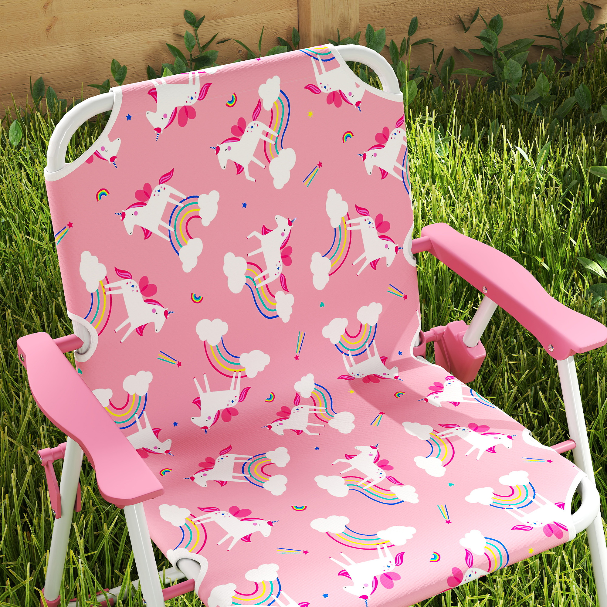 Una sedia da campeggio rosa con unicorni e arcobaleni, sull'erba.