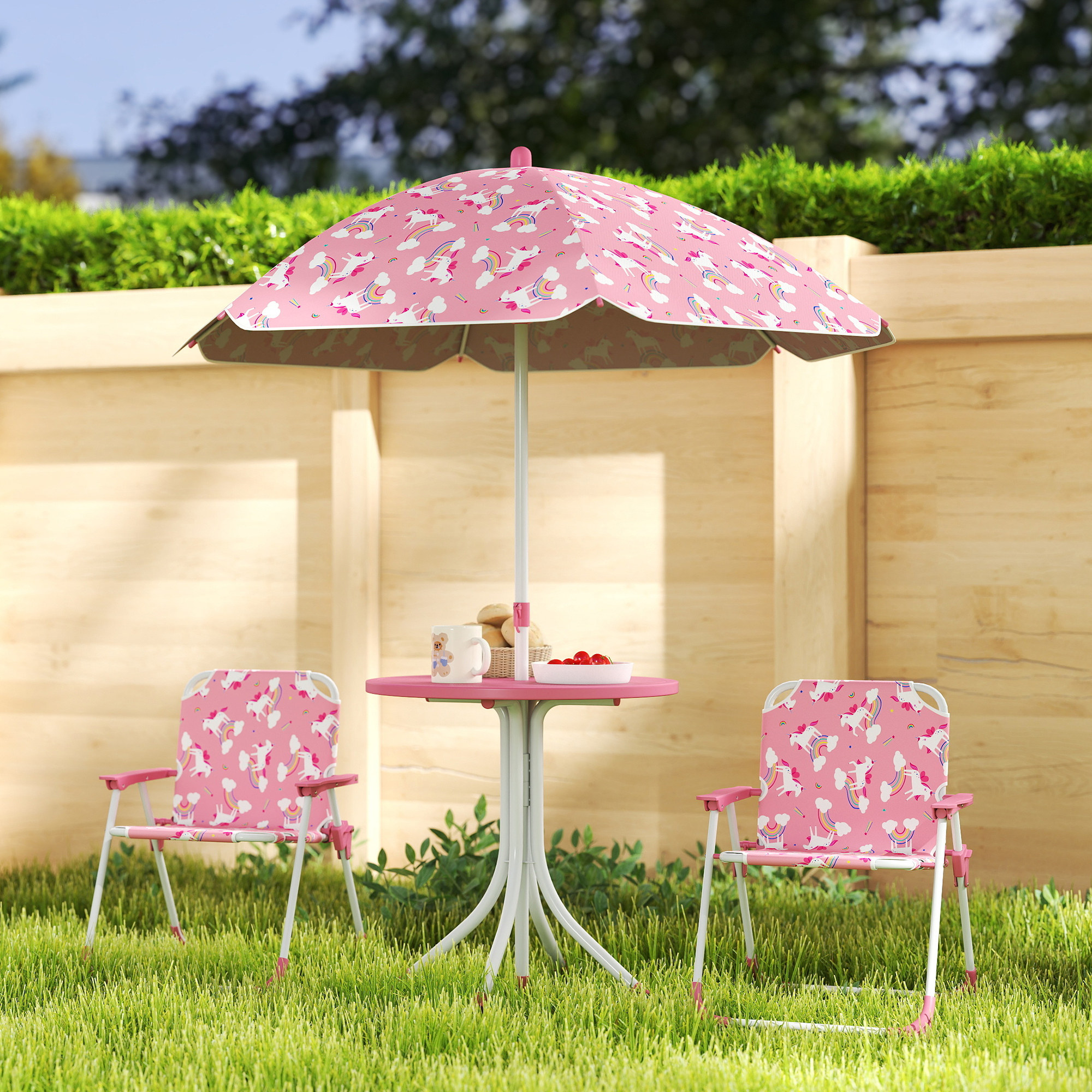 Set da giardino rosa a tema unicorno con due sedie e un tavolo con snack.