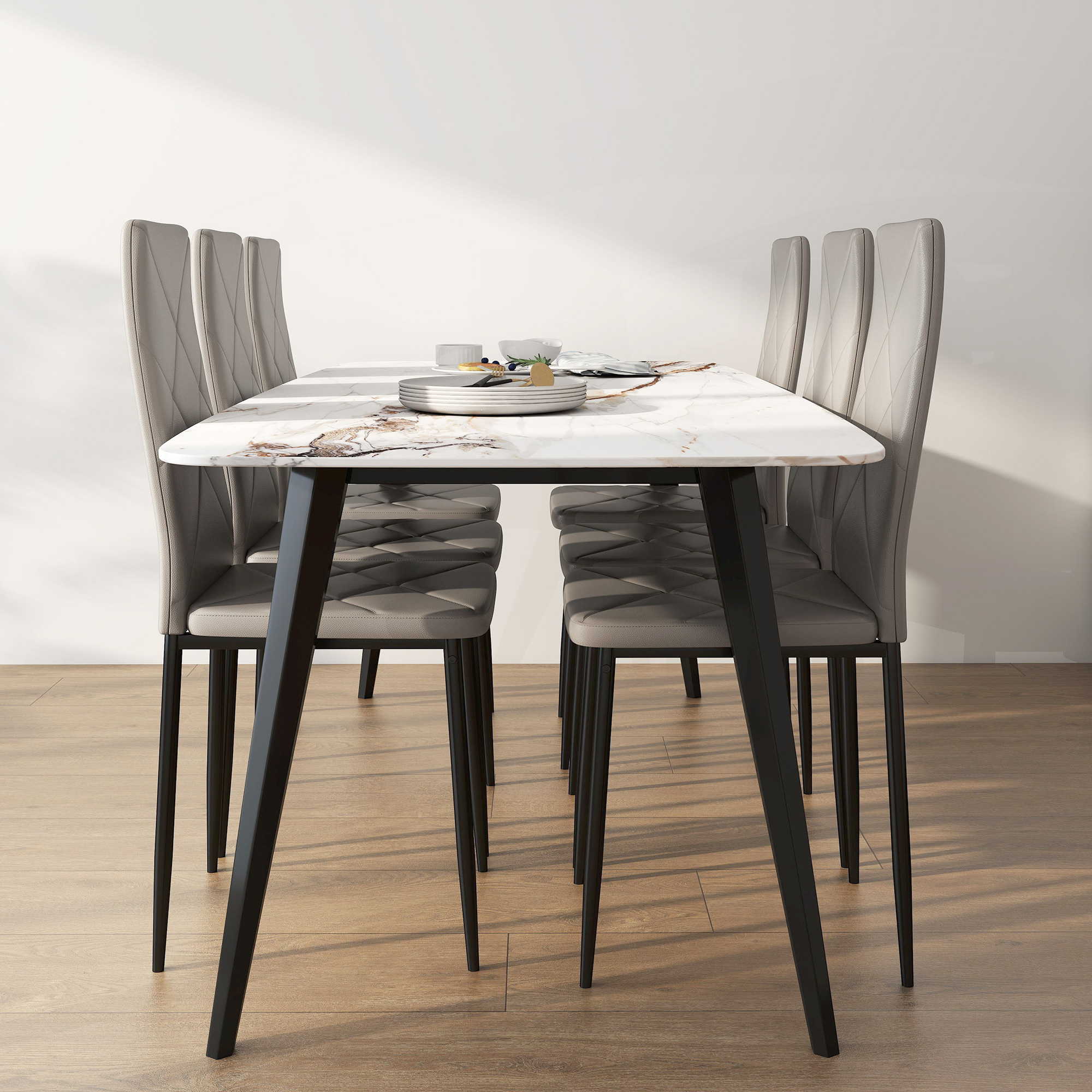 Un tavolo da pranzo con piano in marmo e sei sedie grigie su pavimento in legno.