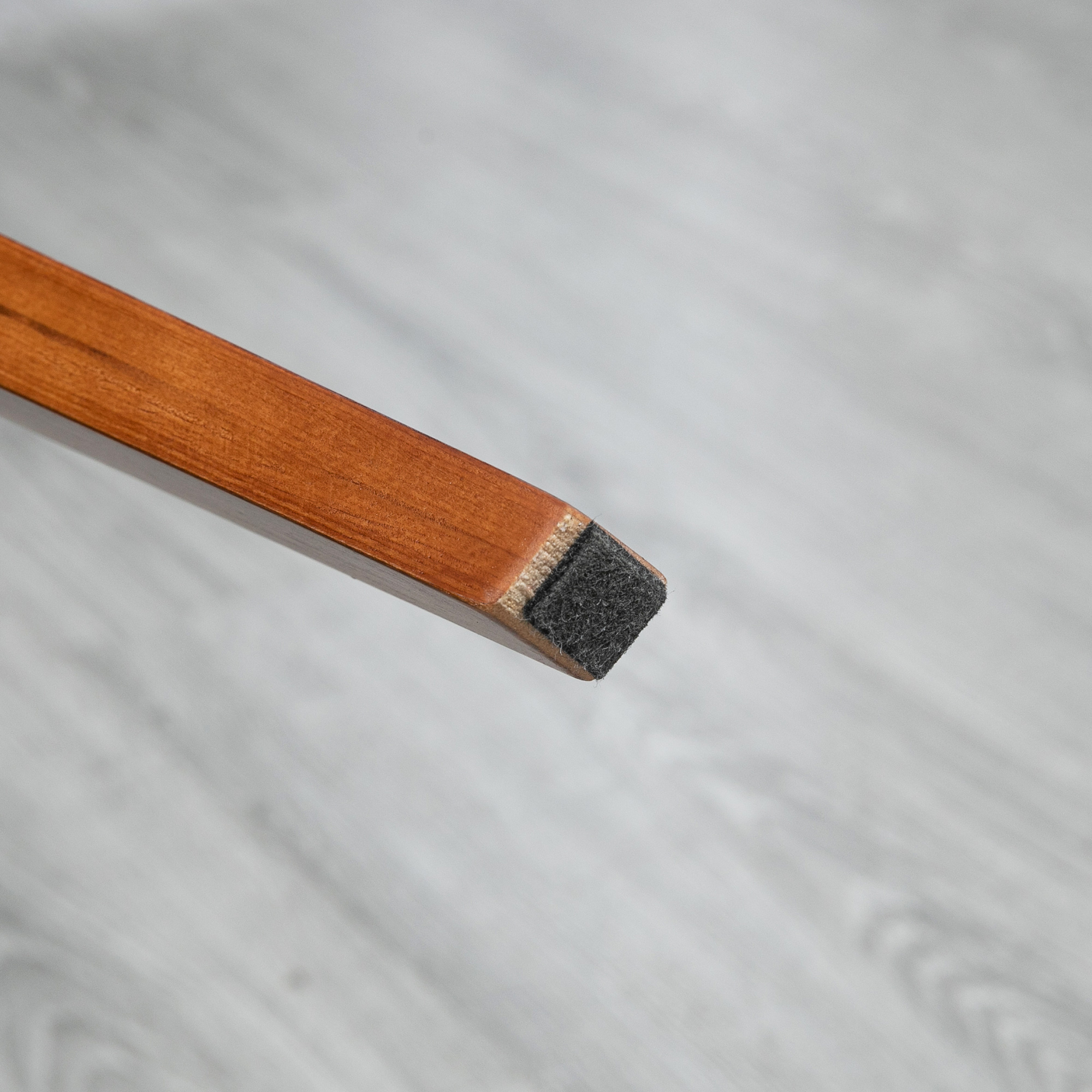 Gamba mobile in legno con feltrino su pavimento chiaro.