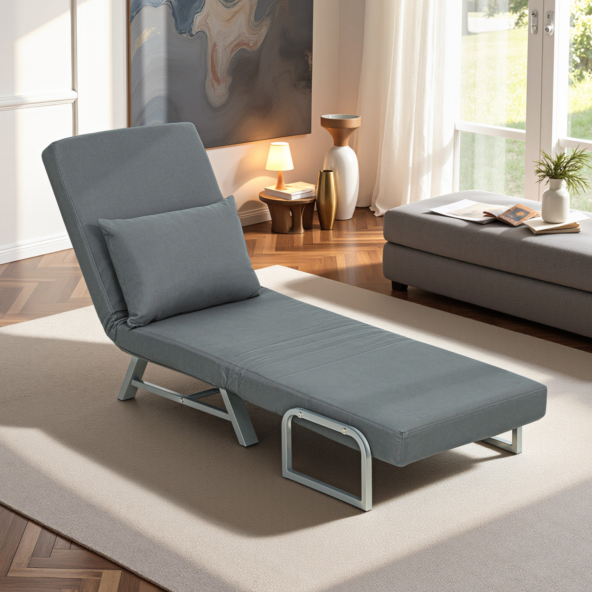 Un divano letto grigio con cuscino è su un tappeto.
