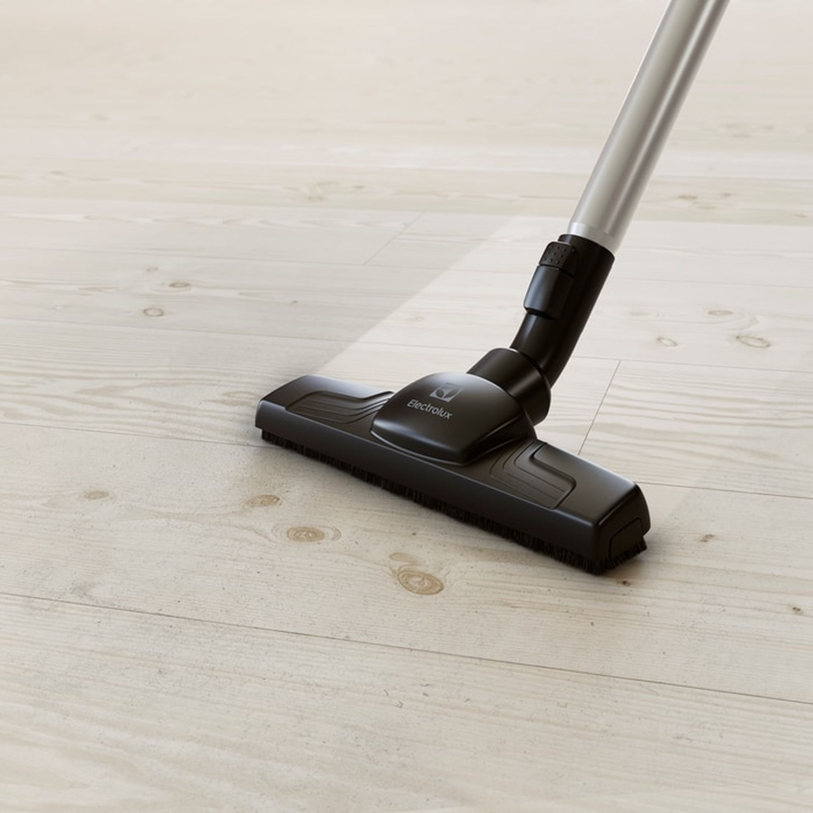 Una aspiradora Electrolux negra sobre un suelo de madera claro.