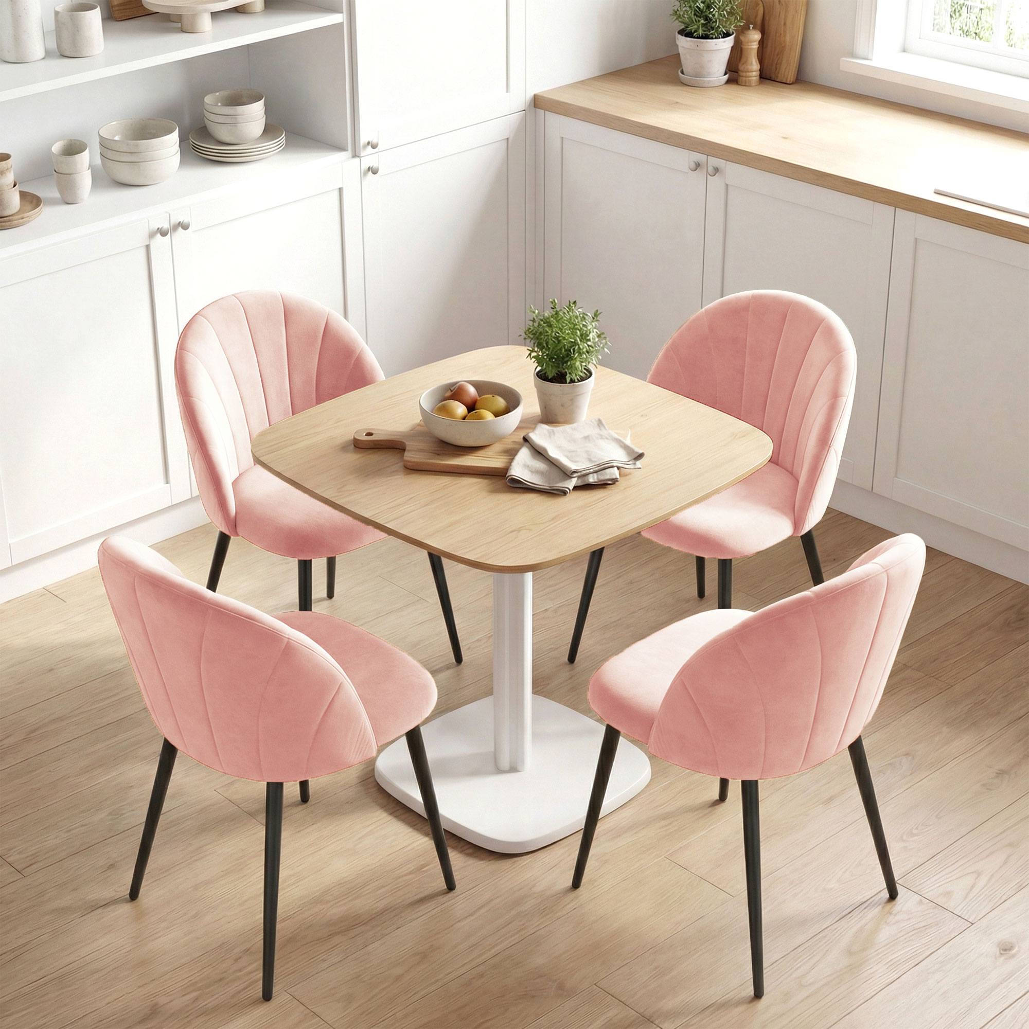 Un tavolo da pranzo con quattro sedie rosa in una cucina bianca.
