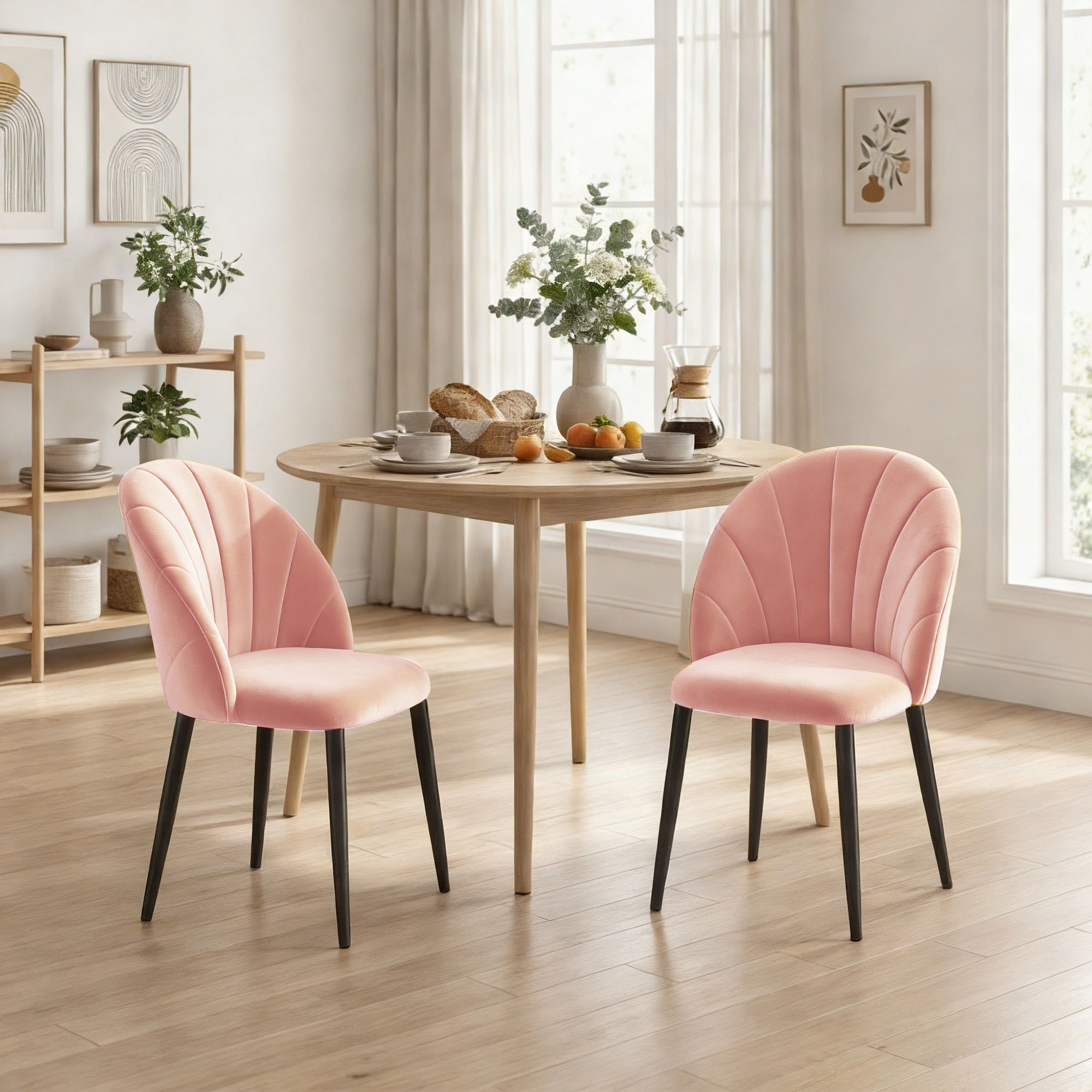 Due sedie in velluto rosa sono accanto a un tavolo di legno con pane e frutta.