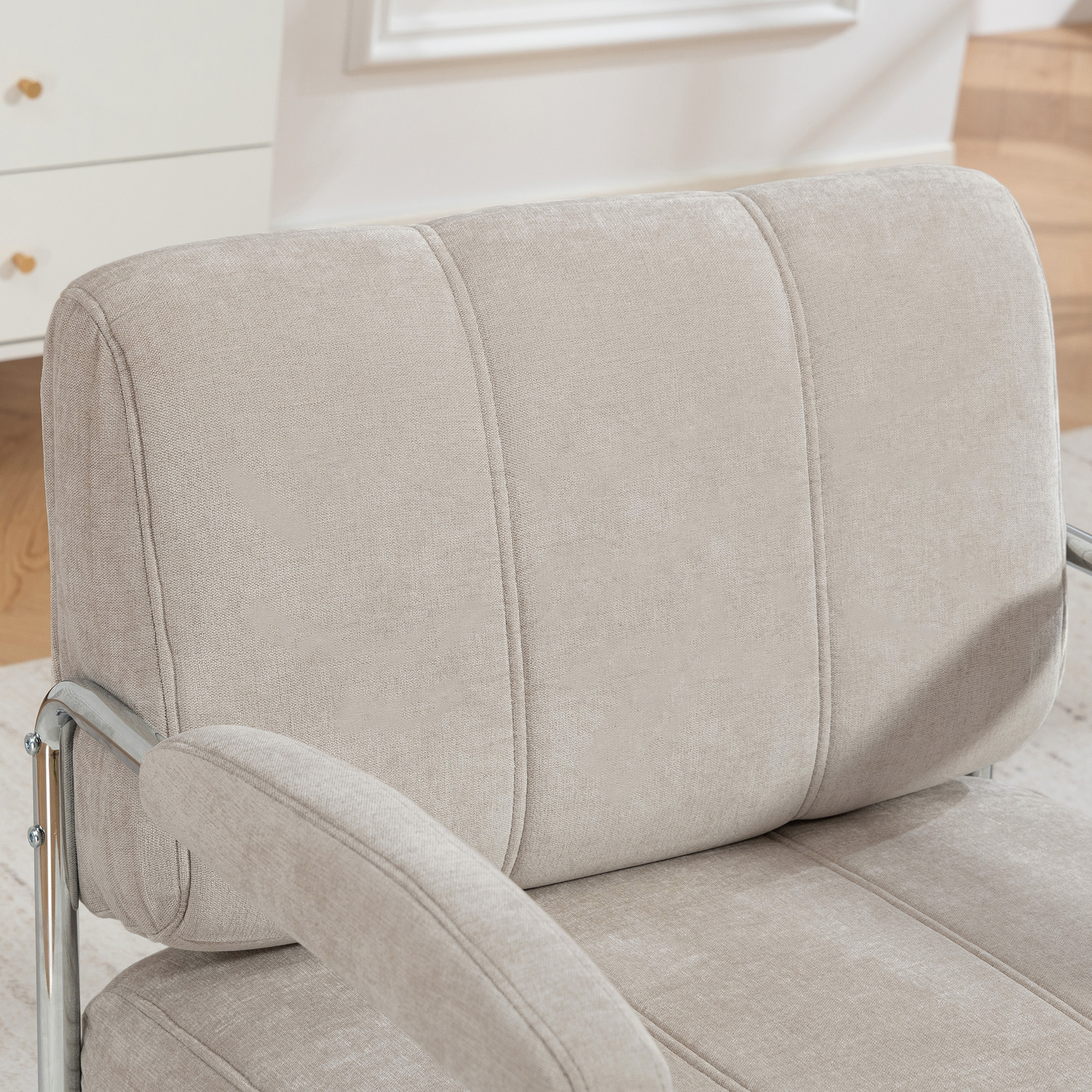 Sedia in tessuto beige con braccioli in metallo argentato e cuciture.