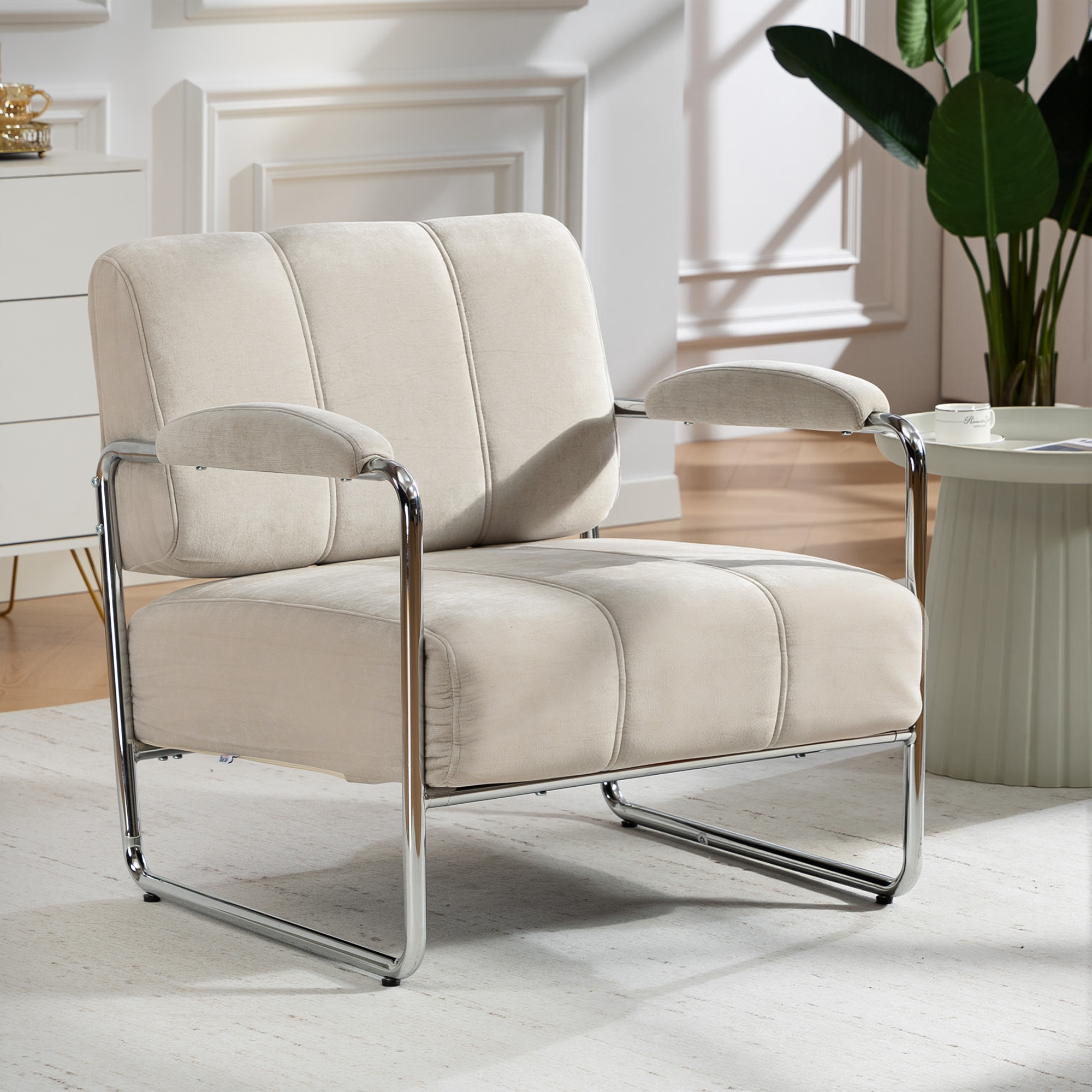 Una poltrona beige con telaio cromato su un tappeto chiaro.
