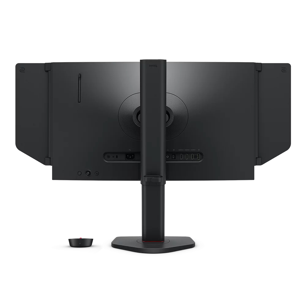 Vista posteriore di un monitor nero sul supporto, con porte visibili. Piccolo dispositivo nero accanto.