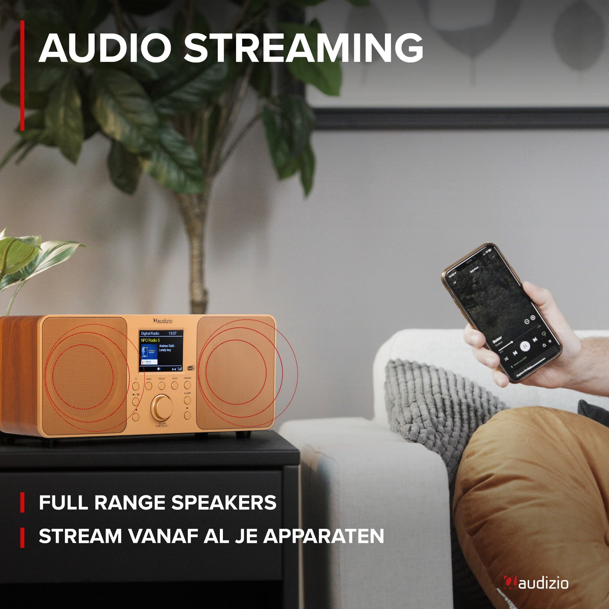 Ein Mann hält ein Smartphone neben einem Audizio-Radio mit Holzdesign.