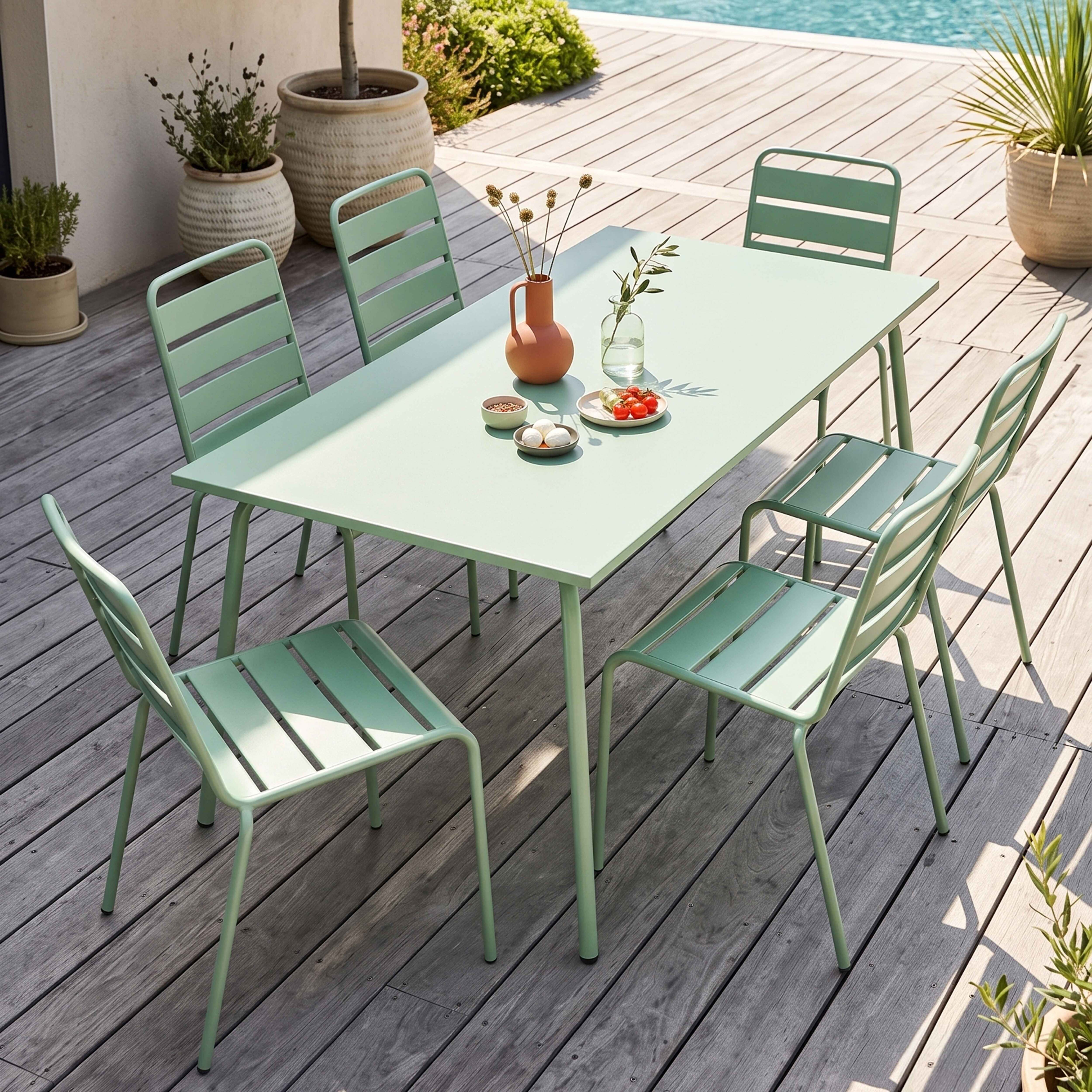 Ein hellgrünes Gartenmöbelset mit Tisch und Stühlen auf Holzterrasse.