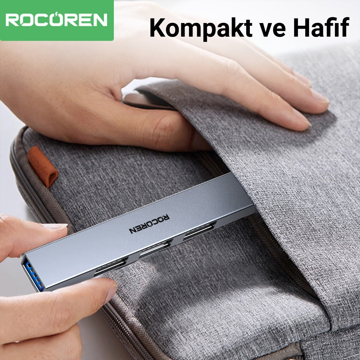 El, mavi portlu gümüş renkli USB-C hub'ı gri dizüstü bilgisayar kılıfına sokuyor.