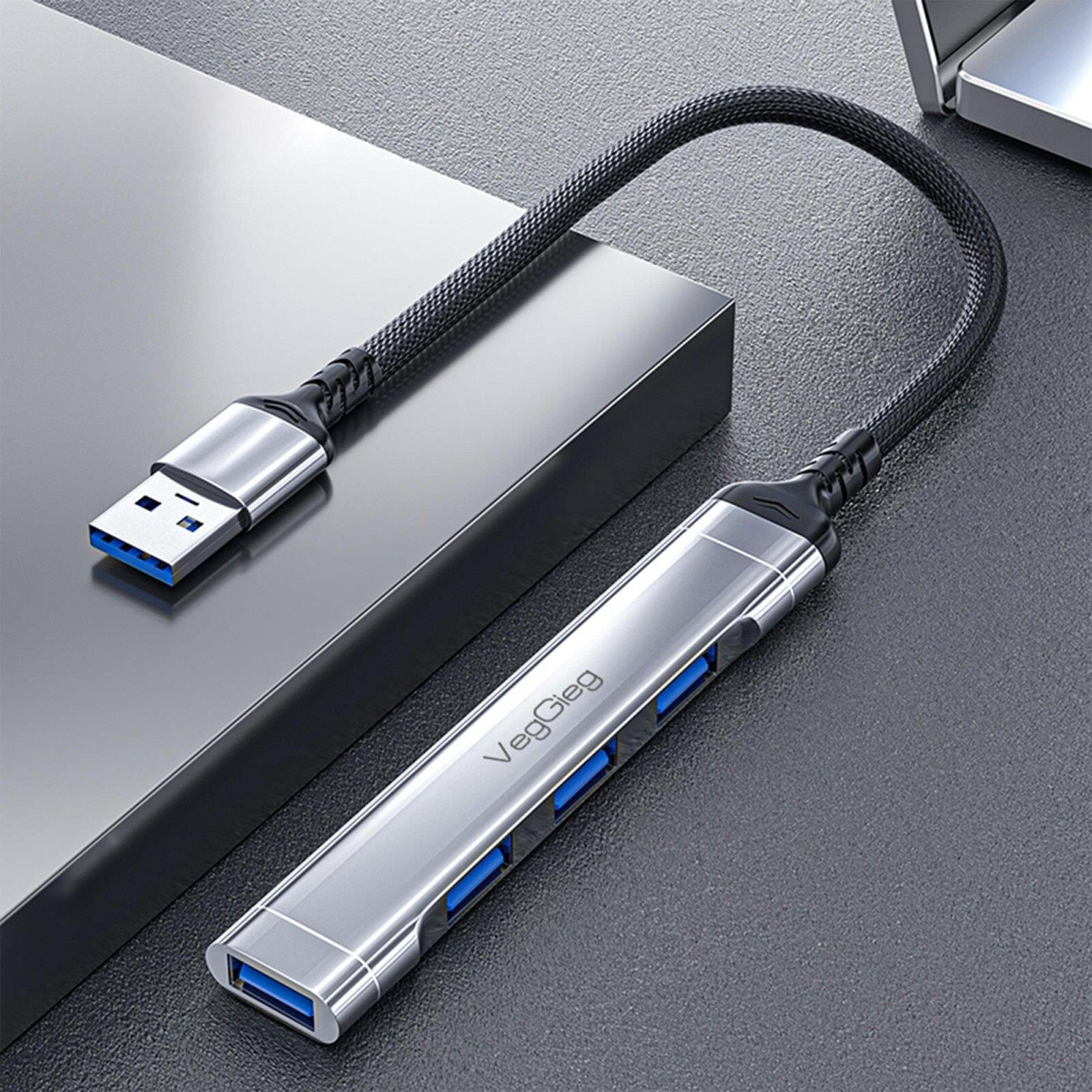 Mavi portlu gümüş renkli USB hub gri bir yüzeyde duruyor.