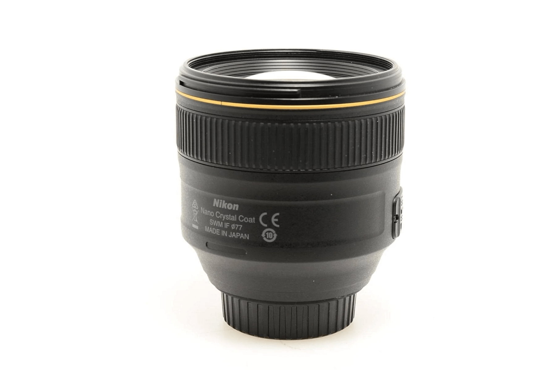 Un objetivo Nikon negro con anillo dorado y marcas de texto.