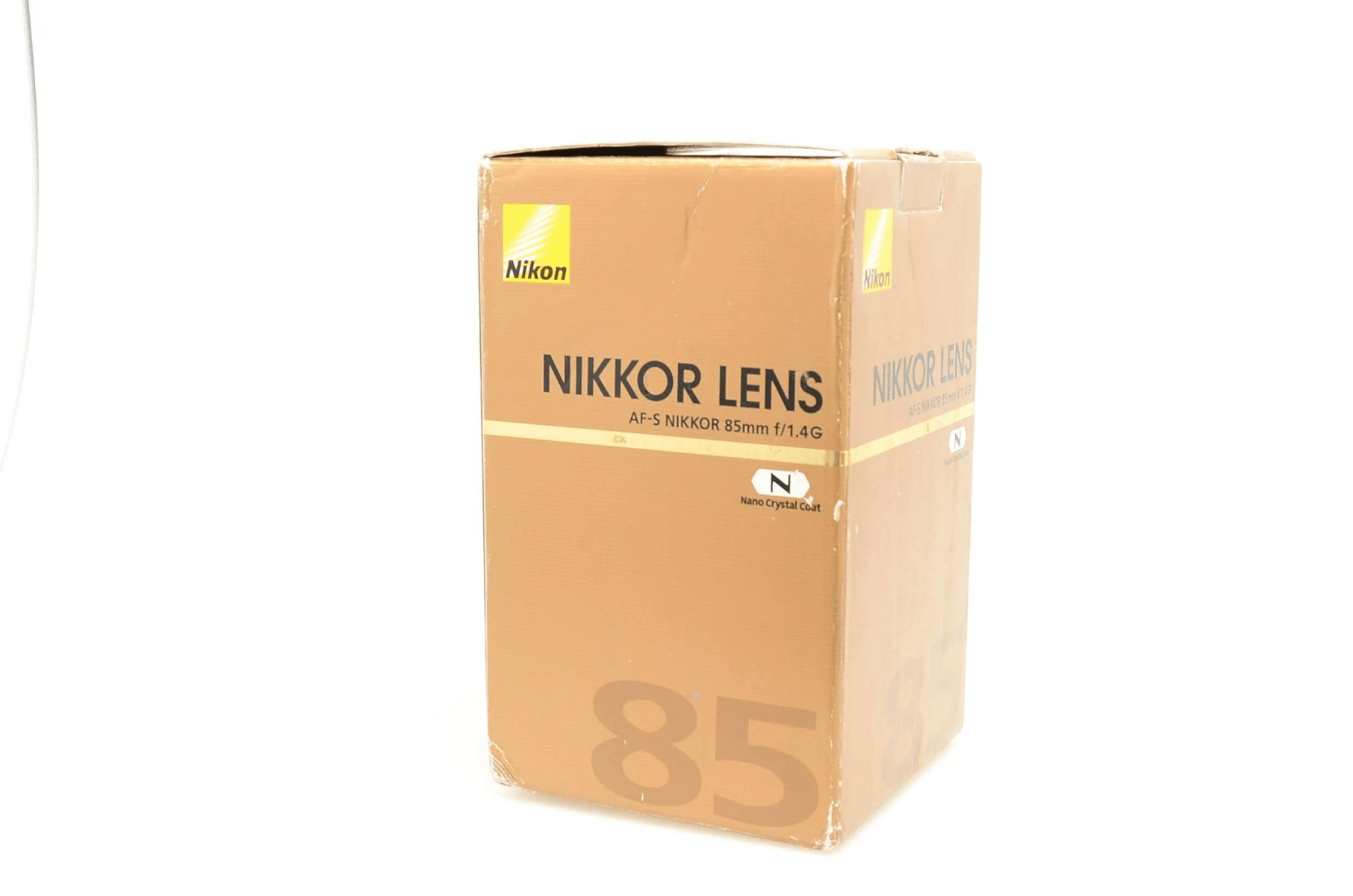 Caja marrón de lente Nikon NIKKOR con '85' y 'Nano Crystal Coat'.