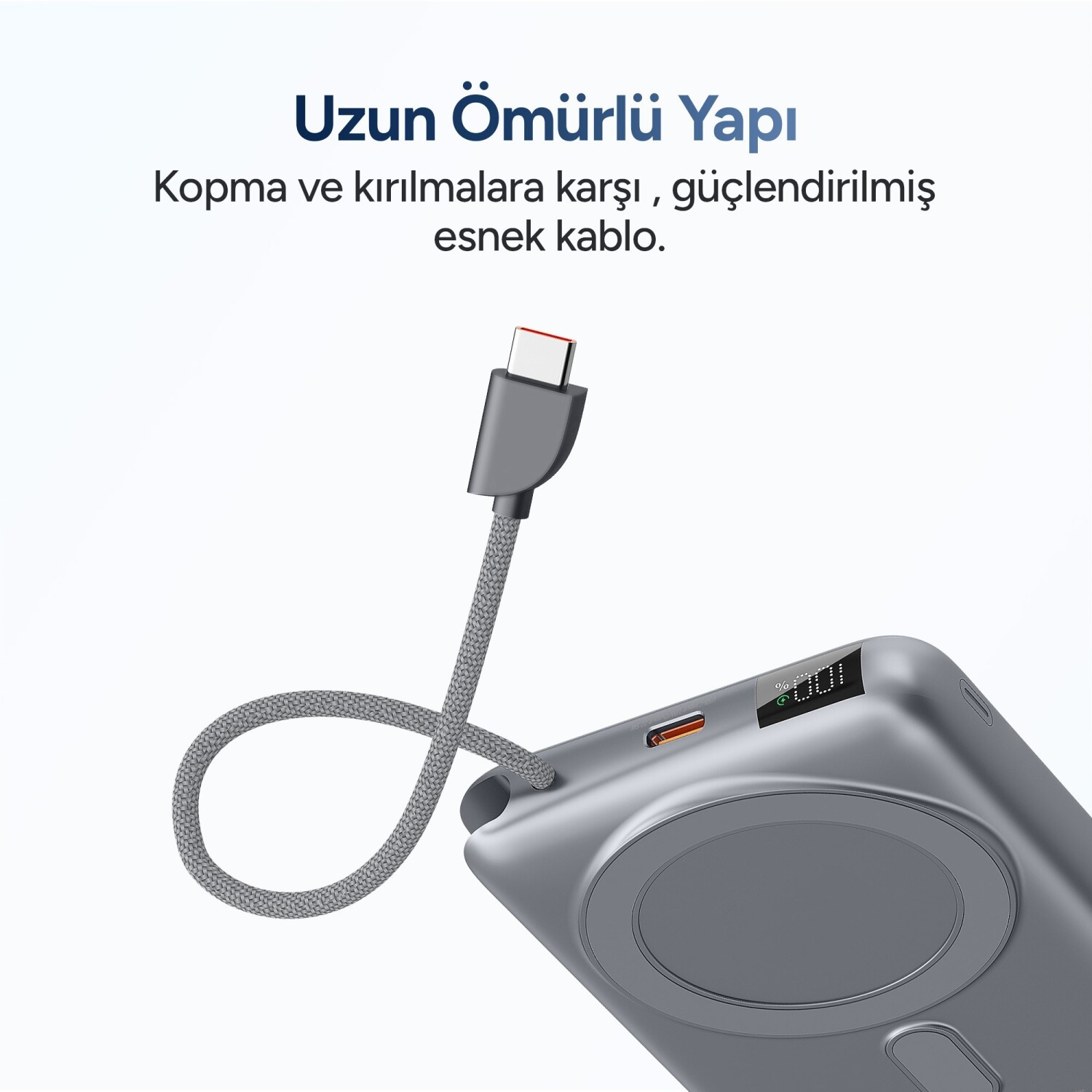 Dijital ekranlı powerbanka bağlı, gri kumaş örgülü USB kablosu.