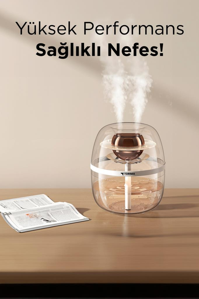 İki buhar çıkışlı nemlendirici, gazetenin yanında ahşap bir masanın üzerinde duruyor.