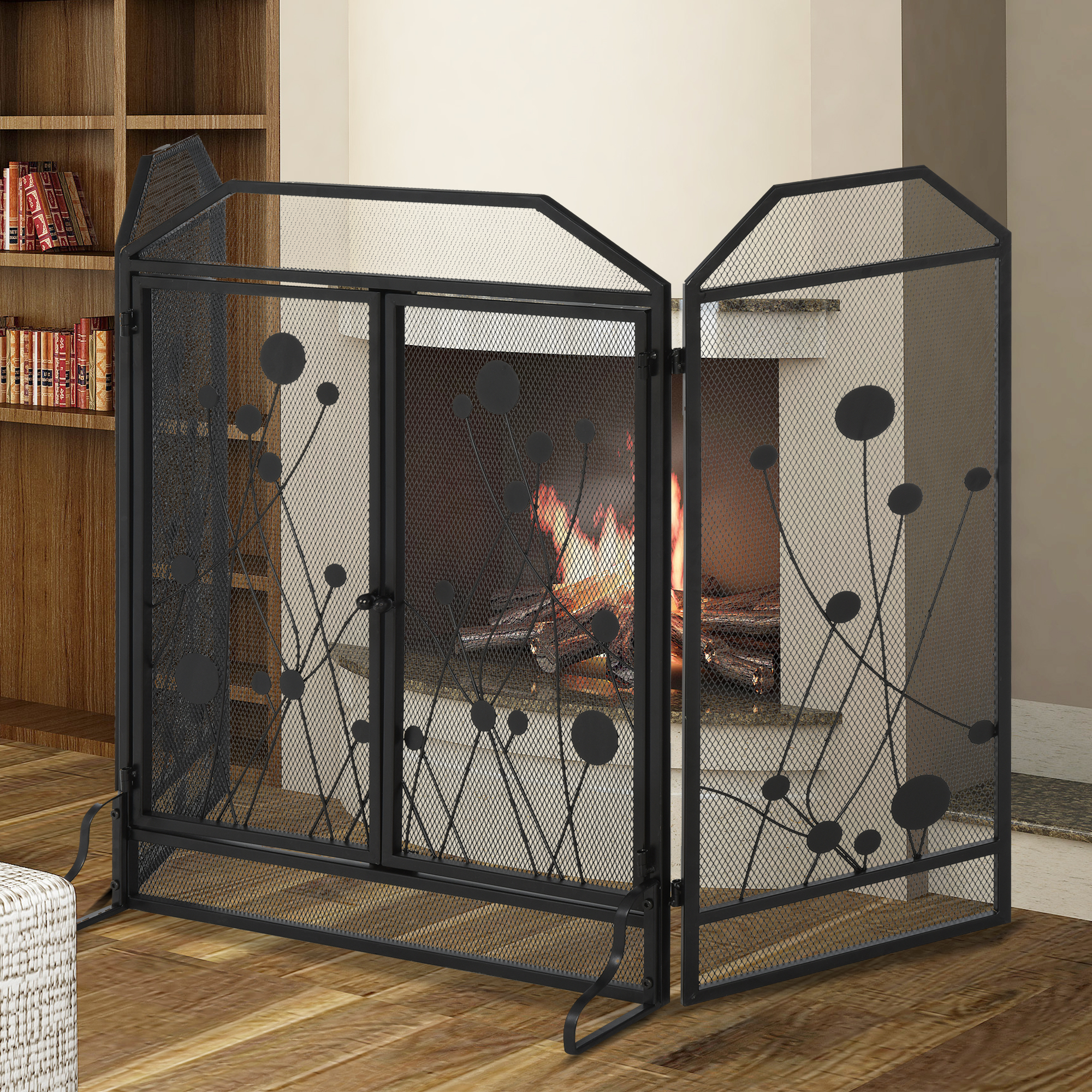 Un parascintille in metallo nero con design floreale protegge un camino acceso.