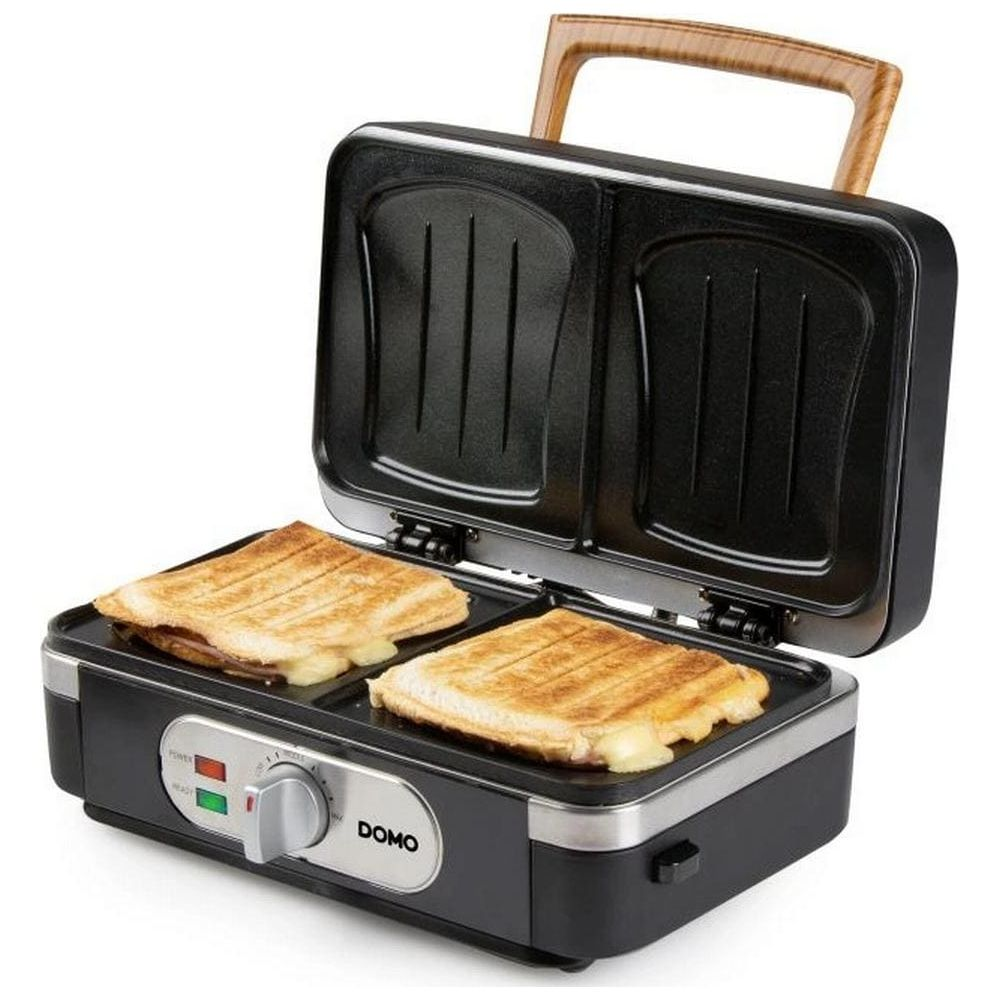 Tostapane nero aperto con due toast al formaggio grigliato dorati all'interno.
