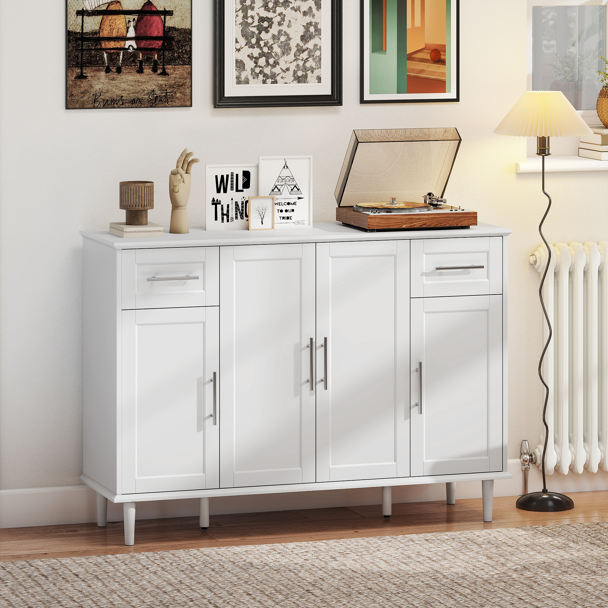 Una credenza bianca con quattro ante e due cassetti si trova contro un muro con opere d'arte.