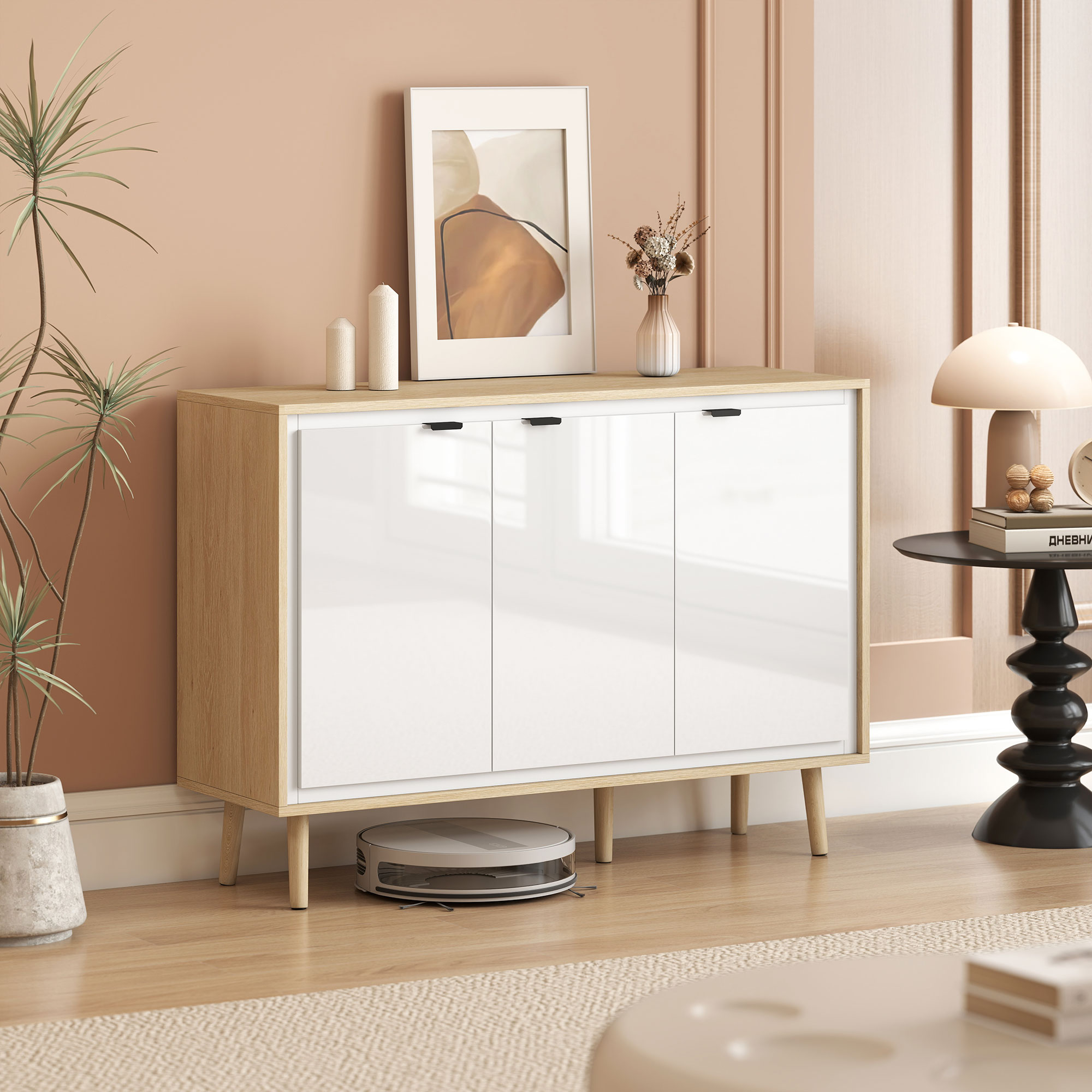 Un mobile bianco con gambe in legno, decorazioni e un robot aspirapolvere sotto.