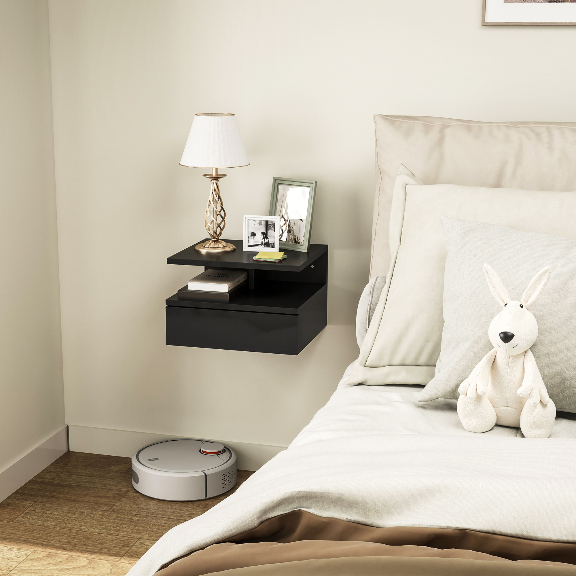 Comodino nero sospeso con lampada, cornici e aspirapolvere robot.