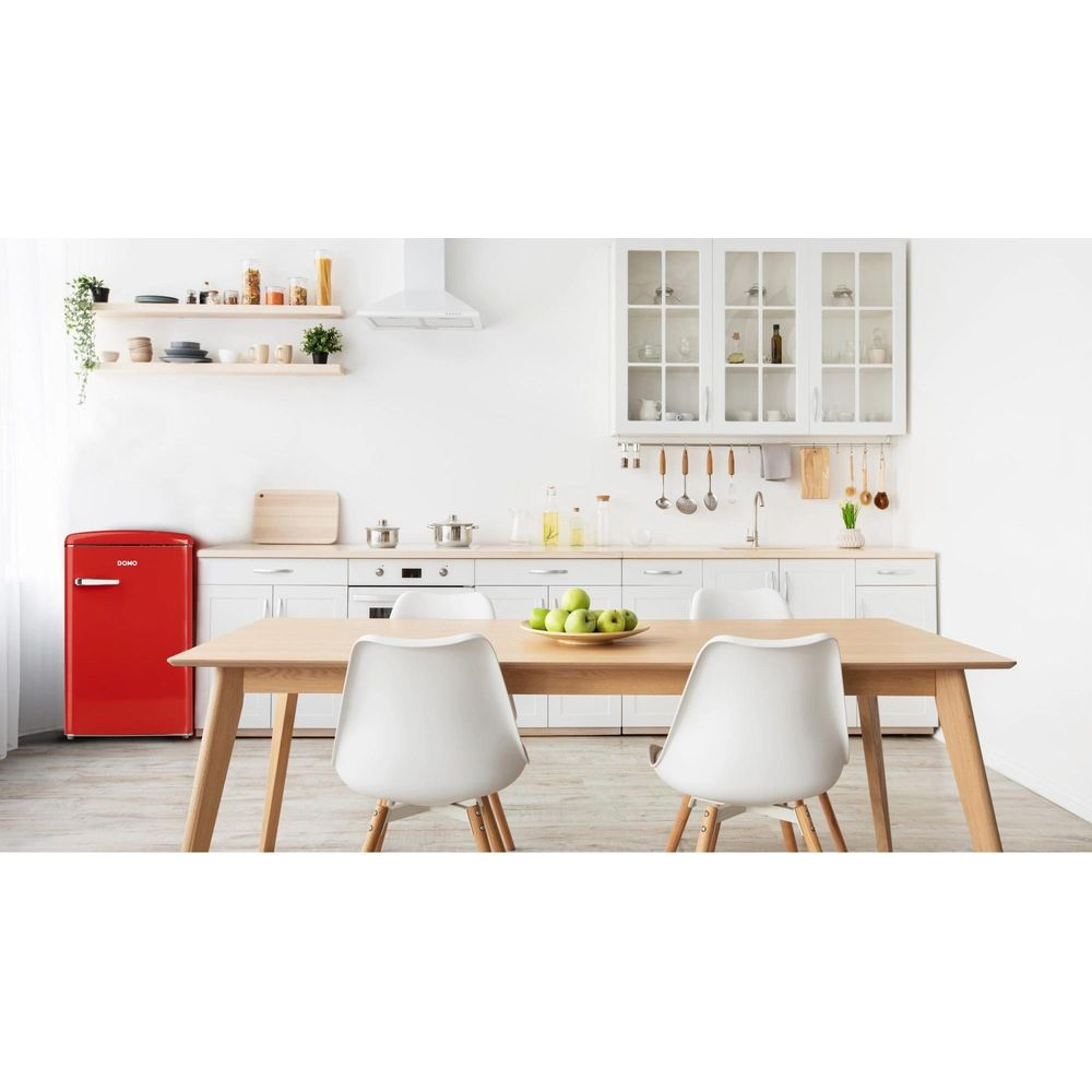 Cucina moderna con frigorifero rosso, tavolo in legno e sedie bianche.